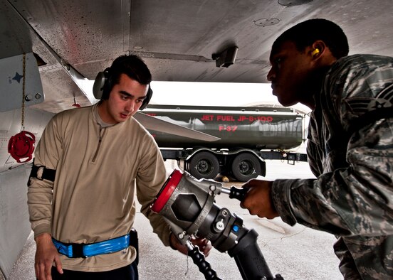 Senior Airman Dion Baynard, 96th Logistics Readiness Squadron, passes the fuel hose to Senior Airman Mark Redmond, 756th Aircraft Maintenance Squadron, to refuel an F-16 after a 33rd Fighter Wing sortie Jan. 25.  F-16s from Luke Air Force Base, Ariz., are being used by the wing to fly local area orientation sorties and develop a “battle rhythm leading up to the arrival of the first F-35 Joint Strike Fighter.  (U.S. Air Force photo/Samuel King Jr.)