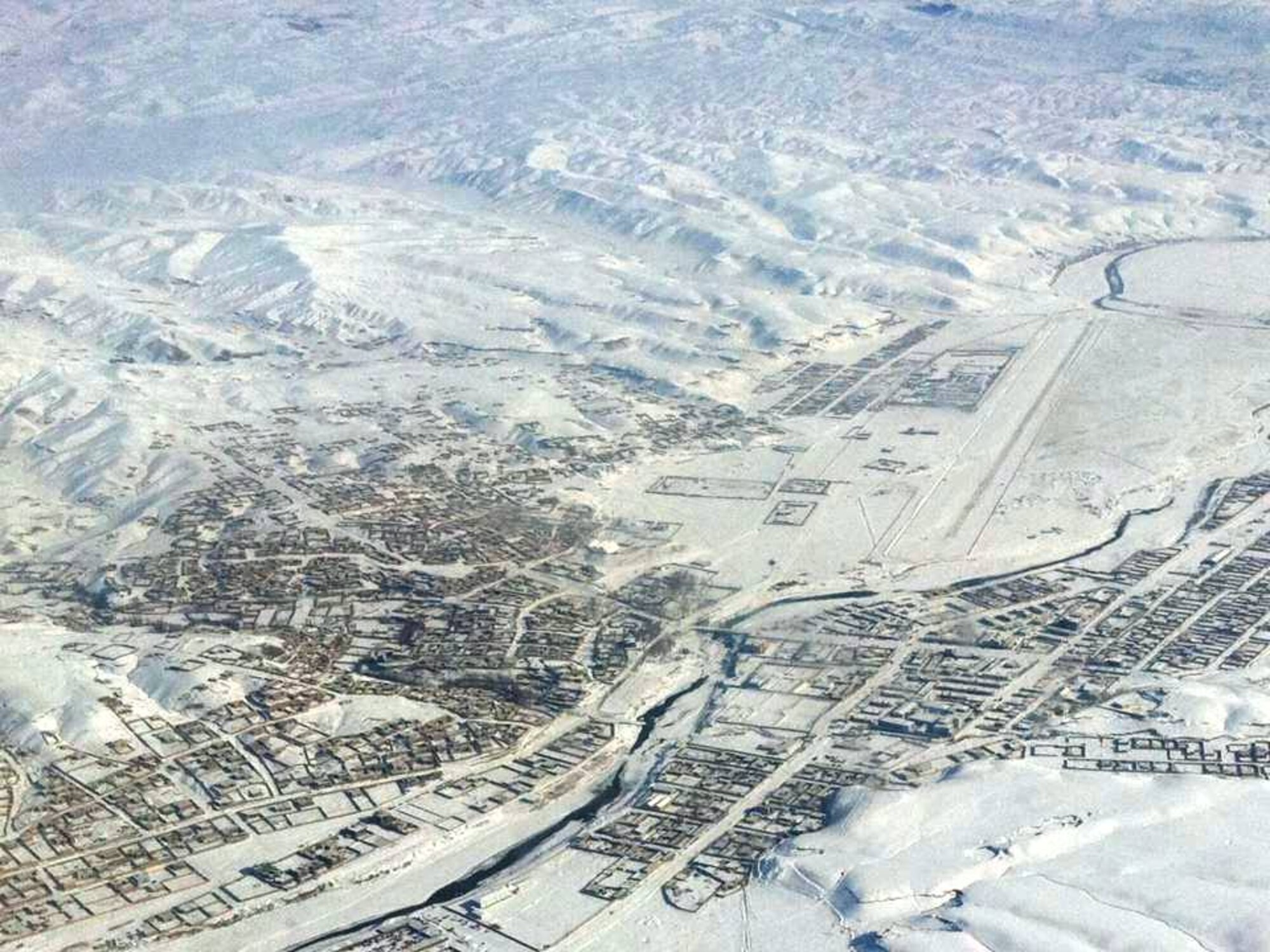 CHAKHCHARAN, Afghanistan - An Afghan Air Force C-27A Spartan transport aircraft flies over the high-elevation, snow covered dirt runway after helping move members of the Afghan National Army from Herat. (U.S. Air Force photo/RELEASED).
