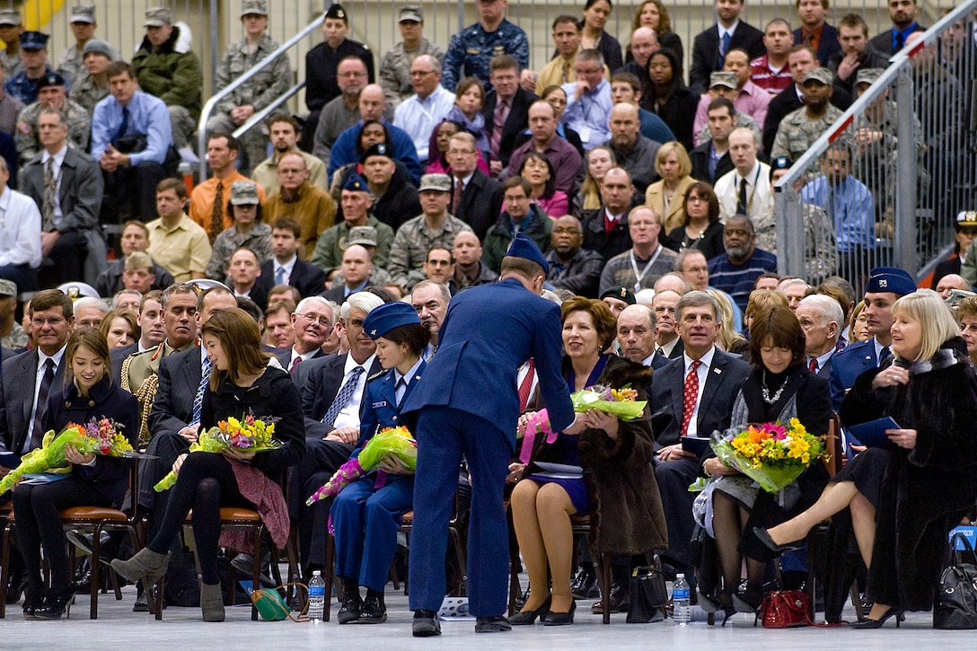 An Air Force airman present flowers to the wives and family members of Air Force Gen. Kevin P. Chilton, outgoing commander, U.S. Strategic Command, and Air Force Gen. C. Robert Kehler, incoming commander, during the change-of-command ceremony on Offutt Air Force Base, Neb., Jan. 28, 2011.