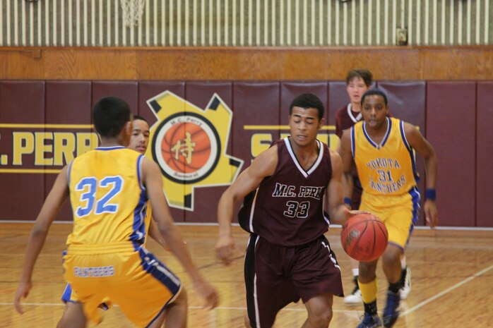 John Ayers Jr., a Matthew C. Perry High School basketball guard, rushes forward, dribbling the ball down the court in a game against Yokota High School at the M.C. Perry High School gym here Saturday. Though the game was a close win for the M.C. Perry team, Yokota won 85-77.
