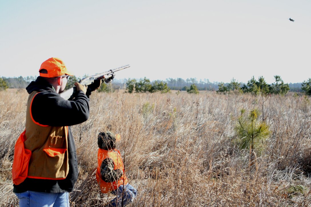 Chief Warrant Officer 3 Gary Stouffer, regimental engineer officer with 10th Marine Regiment, 2nd Marine Division, leads a fleeing quail with his son during the Wounded Warrior Quail Hunt in Roanoke Rapids, N.C., Jan. 29. Wounded Marines and one sailor from Marine Corps Base Camp Lejeune got together at the Big Rack Trophy Club for a day of quail hunting along with various Halifax County supporters.