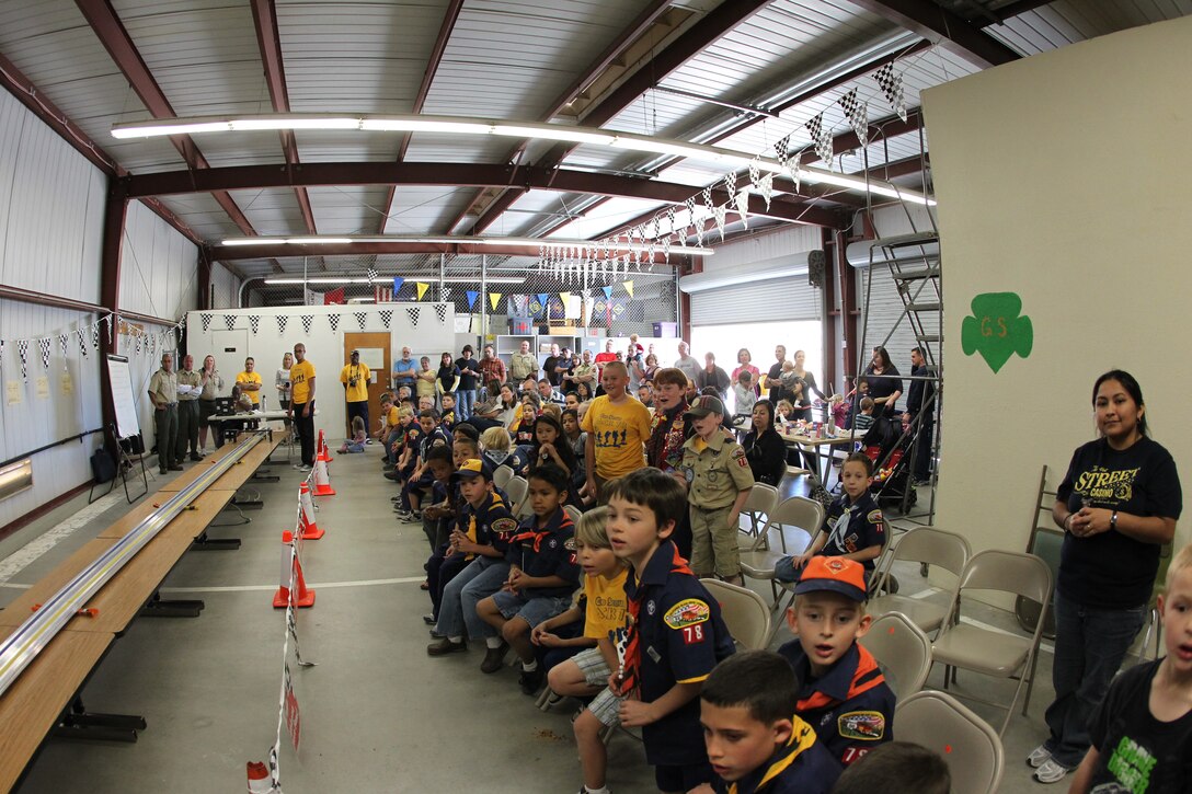 Cub Scouts and families look on in eager anticipation for the start of the next race during the Cub Scouts’ Pinewood Derby at the Combat Center’s Scout Hut Jan. 29, 2011.