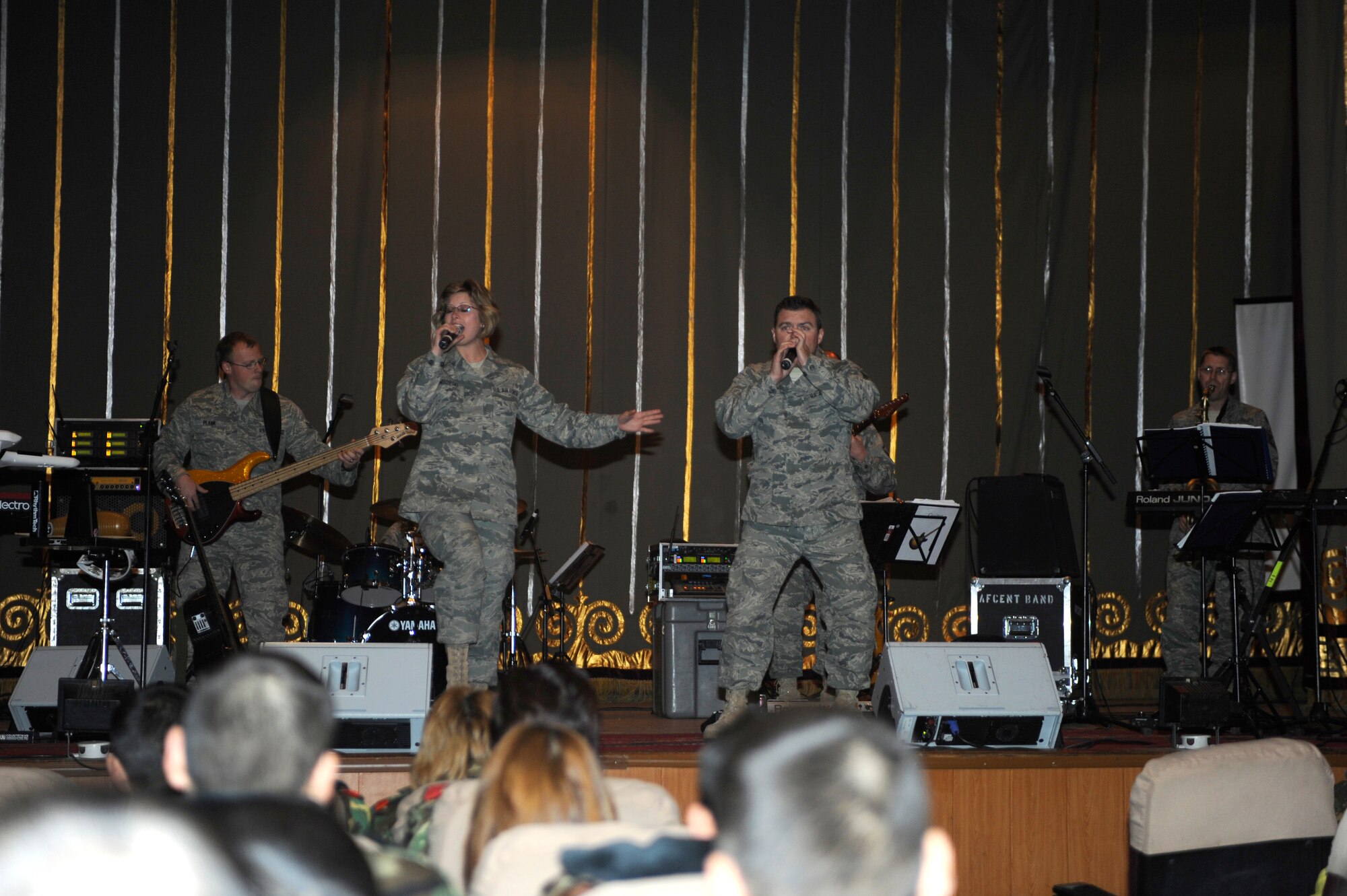 BISHKEK, Kyrgyzstan -- Senior Airman Brian Plank, U.S. Air Forces Central "Starlifter" band bassist holds down the rhythm section while Airman 1st Class Carmen Emborski and Tech. Sgt. Jamie Gilley, lead vocalists, perform an 80s medley at a performance in Frunze--a  Kyrgyz military academy--in Biskek, Thursday.  The Starlifter band performed a wide variety of music for the Kyrgyz military community to enjoy. (U.S. Air Force photo/ Tech. Sgt. Jerome C. Baysmore) 
