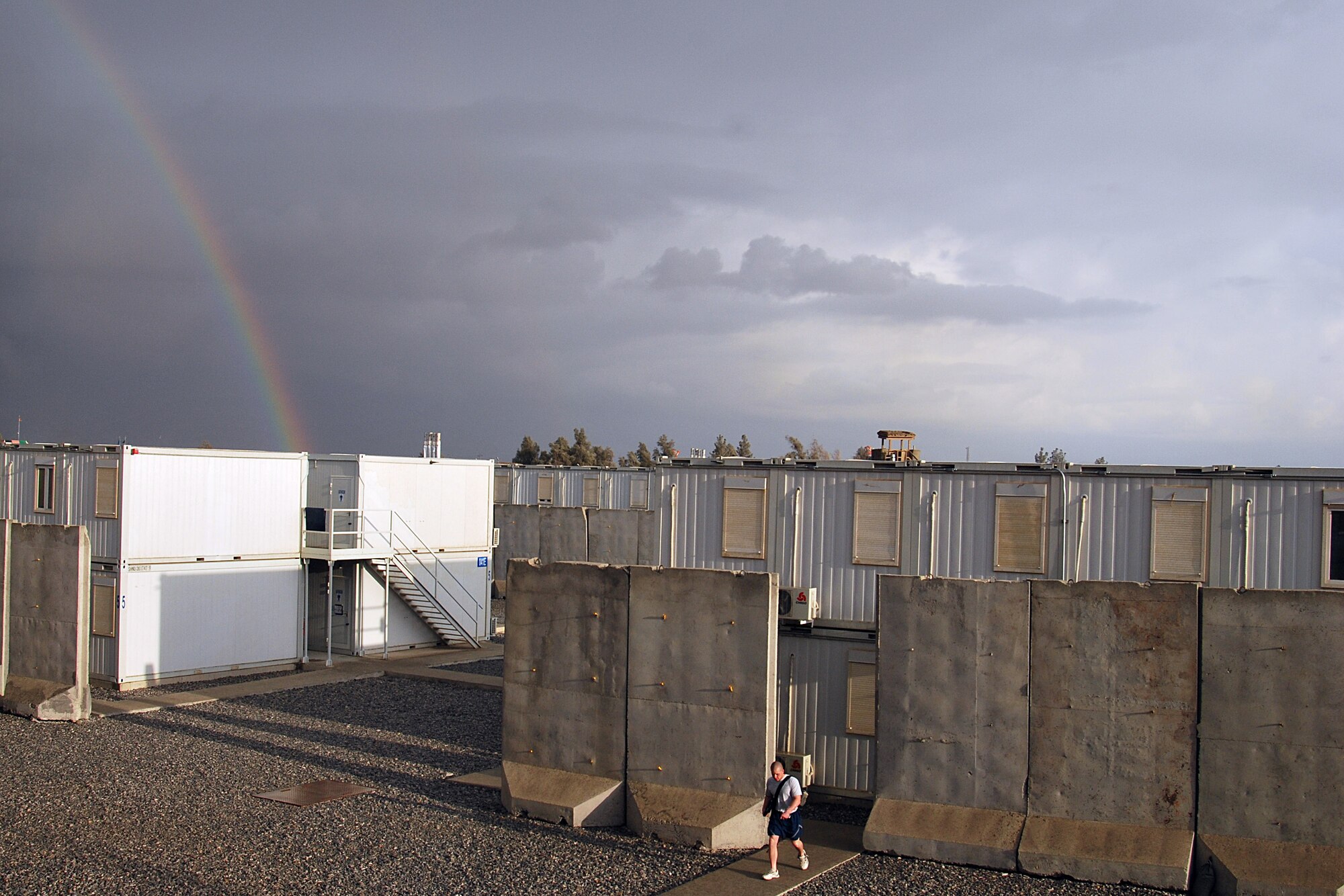 An Airman walks underneath a rainbow Jan. 29, 2011, at Kandahar Airfield, Afghanistan. This week brought the most major storms for the region since the start of the rainy season, which typically begins in November. KAF is home to many military units, including the 451st Air Expeditionary Wing which is supported by nearly 2,000 Airmen. (U.S. Air Force photo/Senior Airman Melissa B. White/Released)