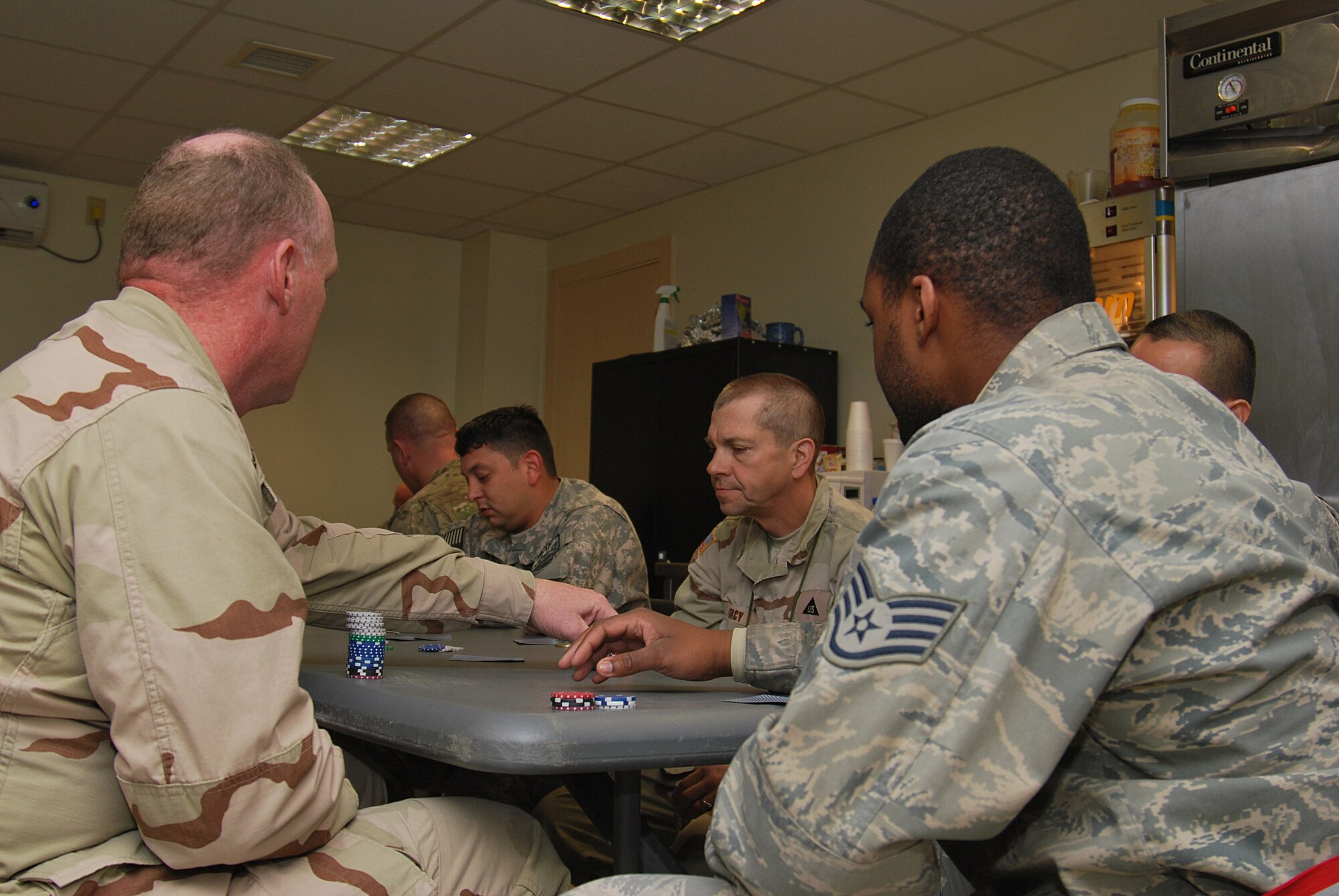 Members from several different military branches gather for poker night Jan. 28, 2011 at the 451st Expeditionary Force Support Flight Morale, Welfare, and Recreation Center on Kandahar Airfield, Afghanistan. The 451st EFSF MWR team hosts nightly events or tournaments to boost the quality of life of nearly 2,000 Airmen assigned to the wing and for whomever else comes to the center for relief from the deployed environment. (U.S. Air Force photo/Senior Airman Melissa B. White / Released)