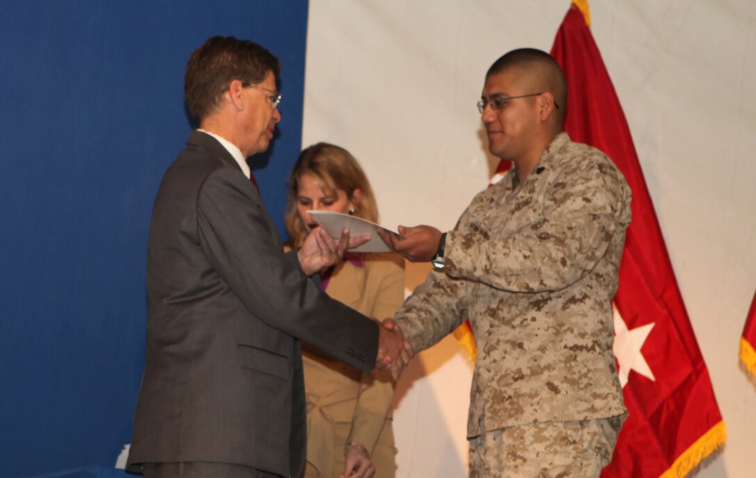 Sgt. Oscar Galindo-Barrios, an aviation electrician with Marine Aviation Logistics Squadron 16, 3rd Marine Aircraft Wing (Forward), receives his Certificate of Naturalization from Mr. Robert V. Looney, a Citizenship and Immigration Services officer, Department of Homeland Security - U.S. citizenship and immigration services, during a naturalization ceremony for U.S. citizenship aboard Kandahar Airfield, Afghanistan, Jan. 29.  Galindo-Barrios was born in Mexico, but grew up in San Diego, Calif., from the age of four.  He has served in the Marine Corps for eight years and is thankful to be called a citizen of the country he defends.