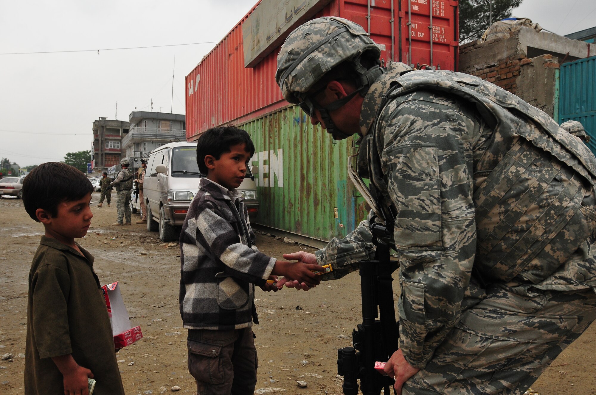 KABUL, Afghanistan - Lt. Col. Kevin Yandura, a NATO Air Training Command - Afghanistan advisor, talks with two young Afghan children during a humanitarian assistance mission.  (U.S. Navy photo by MC1 Elizabeth Burke/RELEASED).
