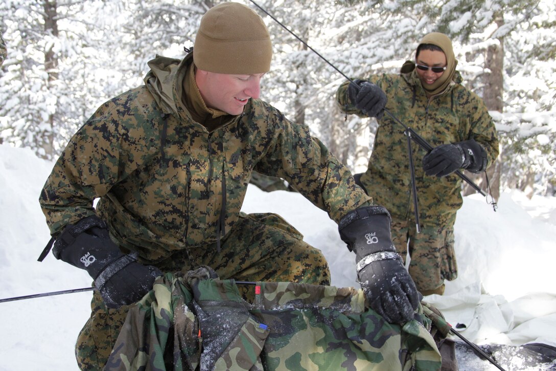 Two corpsman with Headquarters and Services Company, 2nd Battalion, 4th Marine Regiment, perform a “pull pole,” an exercise where the company takes down their tent sites in a quick and efficient manner, Jan. 31, 2011, at the Marine Corps Mountain Warfare Training Center, Bridgeport, Calif.