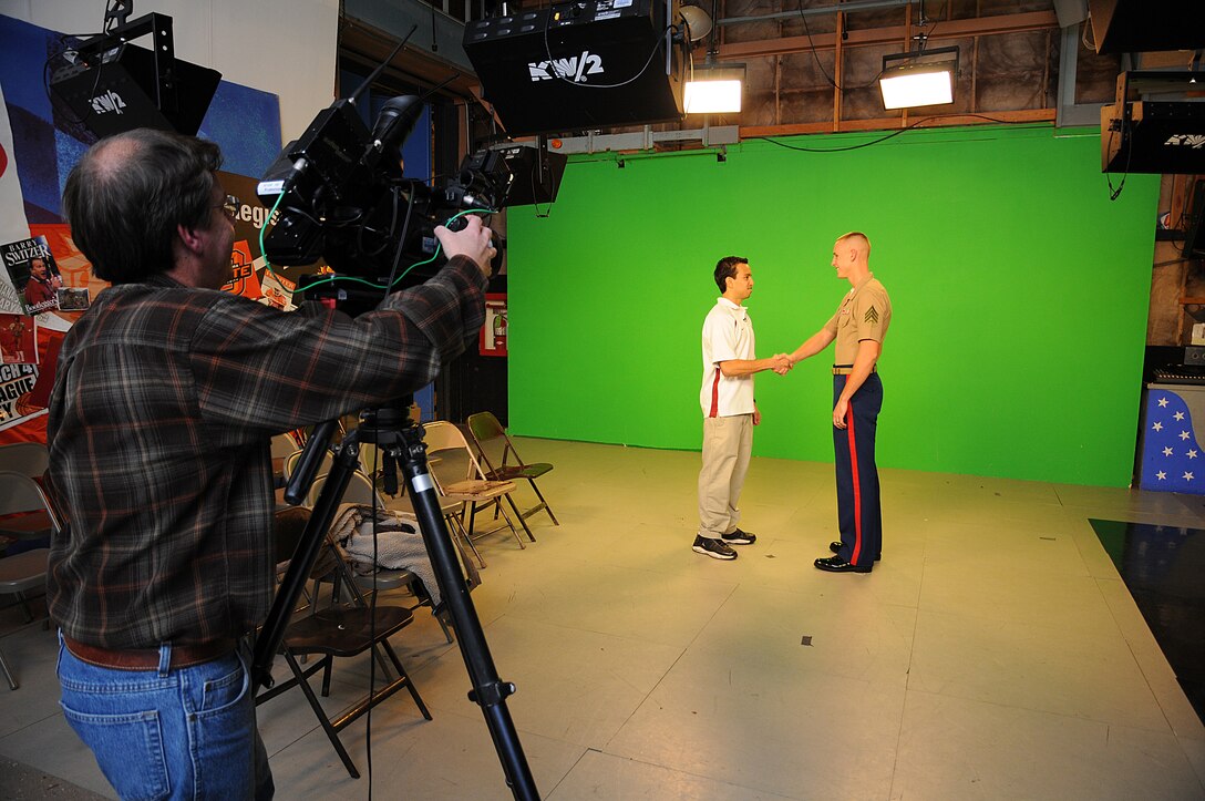 KFOR STUDIOS, OKLAHOMA CITY - (center) Sgt. Daniel Jacobson, a recruiter with Marine Corps Recruiting Station, Oklahoma City shakes hands with Irving Roa, a poolee with RS, Oklahoma City in front of a green screen as part of a promotional concept called the Marine Corps High School Patriot of the Week, is a promotional spot local advertisers support in order to salute the young men and women who choose to join the Corps. This promotion idea was brought to the news station as a way to supplement Marine Corps advertising.