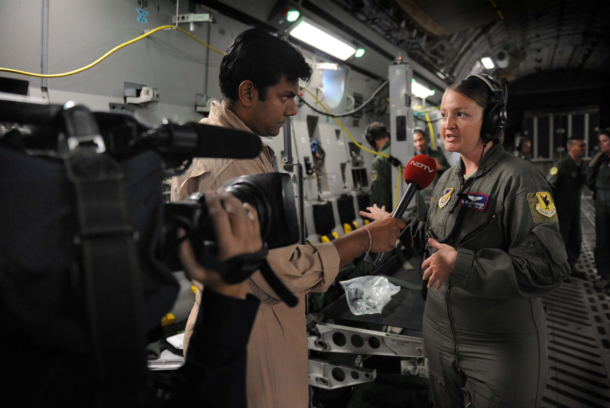 Vishnu Som, New Delhi Television station senior news anchor, interviews Master Sgt. Erin Barger, 18th Aeromedical Evacuation Squadron aeromedical evacuation technician instructor, aboard a C-17 Jan. 25. The NDTV crew flew aboard the C-17 and documented the capabilities of the aircraft on a routine training mission to Kona, Hawaii. (U.S. Air Force photo/Airman 1st Class Lauren Main)