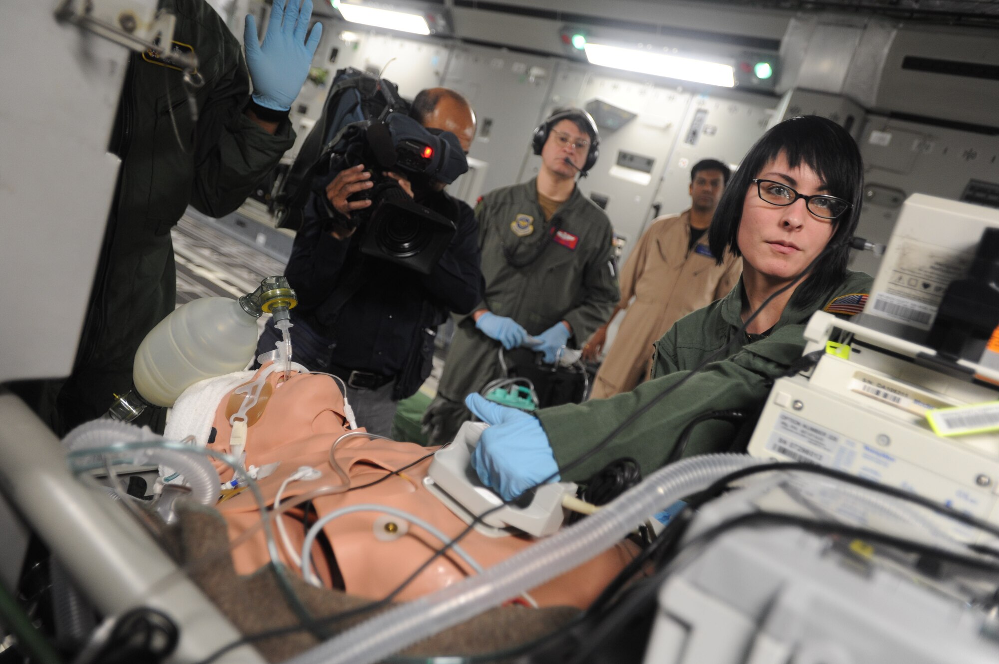 Ajmal Jami, a cameraman from the New Delhi Television station, documents the 18th Aeromedical Evacuation Squadron as they simulate a casualty exercise aboard a C-17 Jan. 25. The NDTV crew flew aboard the C-17 and documented the capabilities of the aircraft on a routine training mission to Kona, Hawaii. (U.S. Air Force photo/Airman 1st Class Lauren Main)