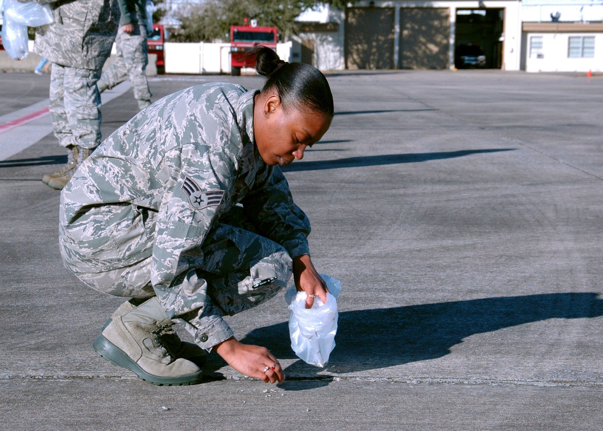 On the Duke Field flightline, Senior Airman Natassa Evans, 919th Force Support Squadron, finds and removes foreign objects Jan. 27 that could potentially damage operating aircraft .  The wing commander called on volunteers to help prepare the tarmac for the return of its aircraft temporarily stationed at nearby Eglin Air Force Base, Fla., during an eight-month airfield construction project.  (U.S. Air Force photo/Adam Duckworth)