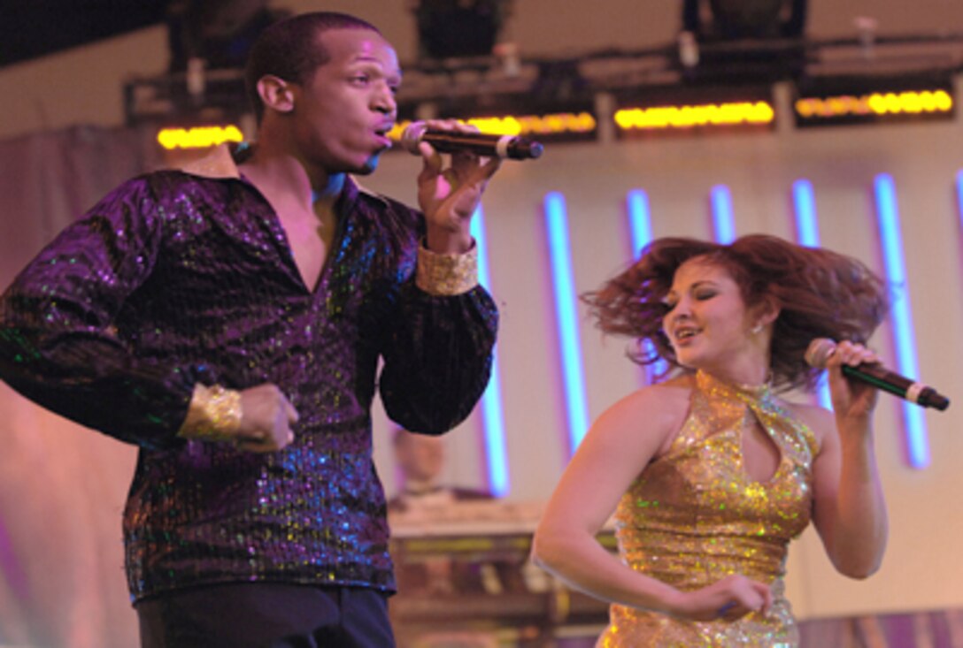 Tops In Blue vocalists Senior Airman Quentin Thomas and 2nd Lt. Rhoda Lazo perform before a large crowd Feb. 11, 2009, in Las Vegas. Tops In Blue, the Air Force's expeditionary entertainment unit, is scheduled to perform "America the Beautiful" during festivities leading up to Super Bowl XLV in Arlington, Texas, Feb. 6, 2011. (U.S. Air Force photo/Senior Airman Larry E. Reid Jr.)