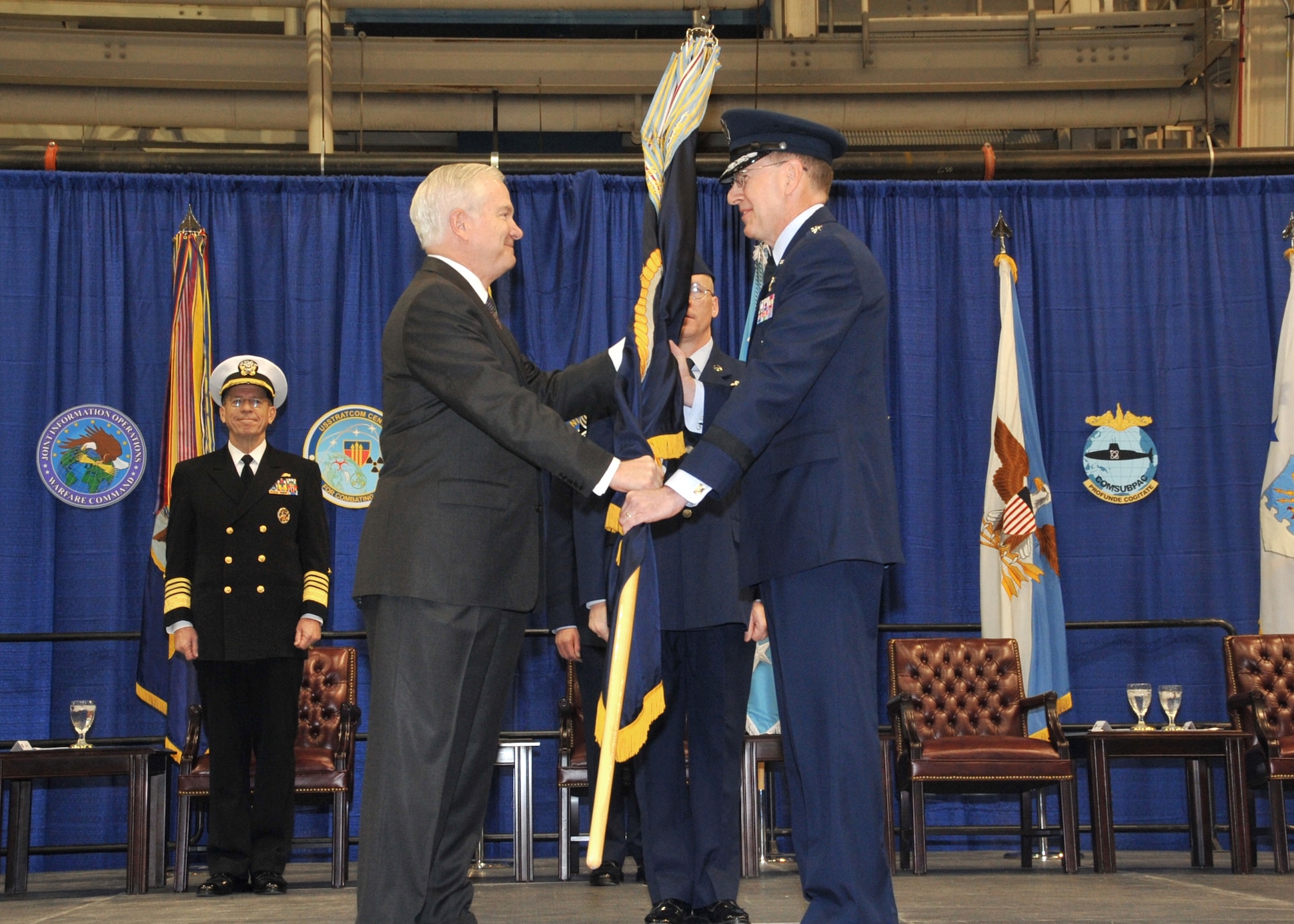 Secretary of Defense Robert Gates presents the U.S. Strategic Command flag to Gen. C. Robert Kehler during the change-of-command ceremony Jan. 28, 2011, at Offutt, Air Force Base, Neb., as Adm. Mike Mullen, chairman of the Joint Chiefs of Staff looks on.  General Kehler was taking command from Gen. Kevin P. Chilton who retired following the change of command.  (Defense Department photo)