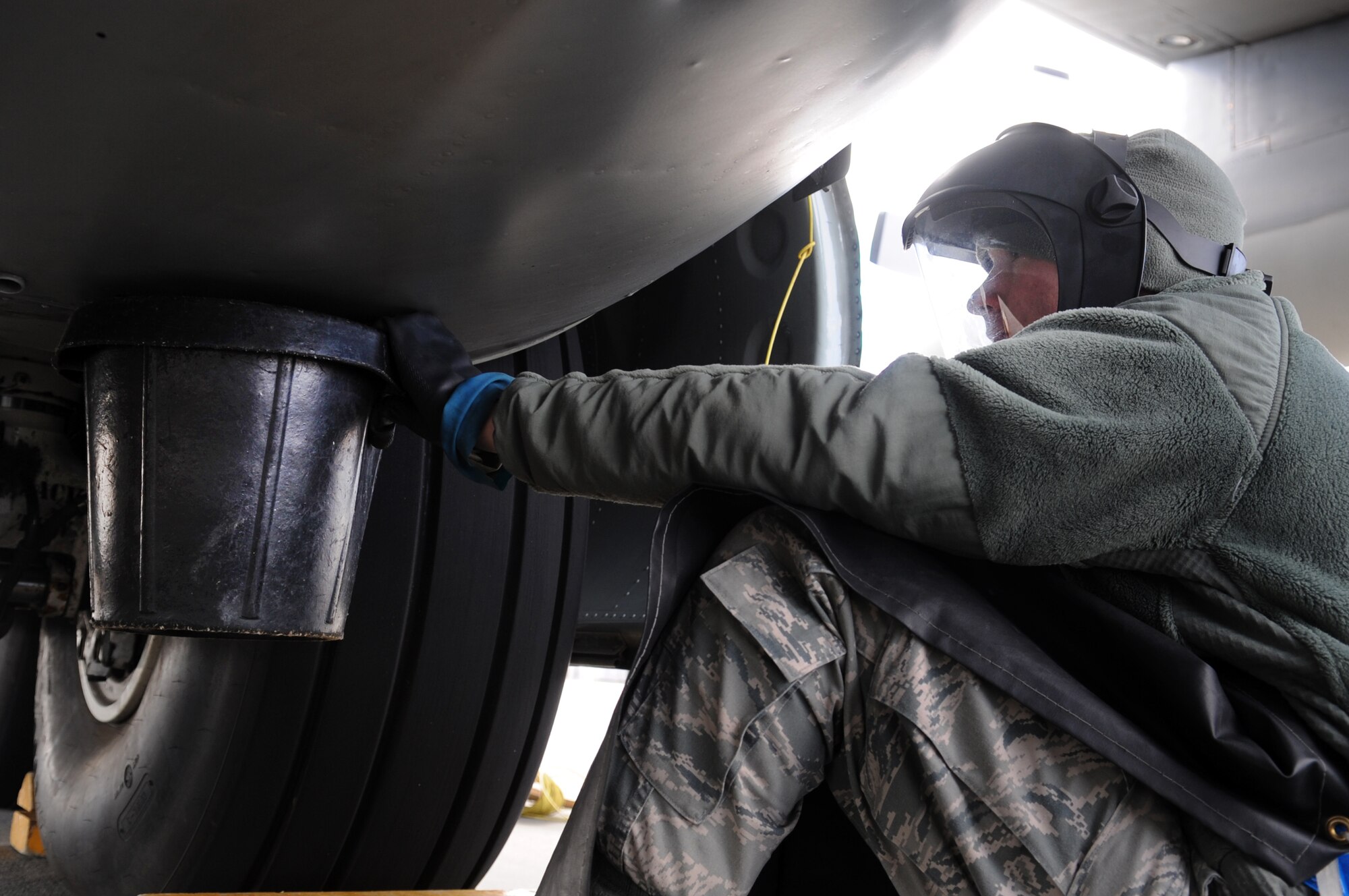 MOODY AIR FORCE BASE, Ga. -- Airman 1st Class Bryce Holsapple, 71st Aircraft Maintenance Unit crew chief, drains a manifold on a HC-130P Combat King Jan. 26. The fuel is drained to prevent it from igniting in the event that a tire explodes. (U.S. Air Force photo/Airman 1st Class Douglas Ellis)(RELEASED)
