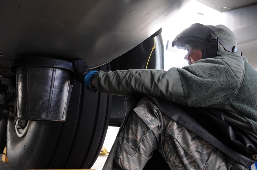 MOODY AIR FORCE BASE, Ga. -- Airman 1st Class Bryce Holsapple, 71st Aircraft Maintenance Unit crew chief, drains a manifold on a HC-130P Combat King Jan. 26. The fuel is drained to prevent it from igniting in the event that a tire explodes. (U.S. Air Force photo/Airman 1st Class Douglas Ellis)(RELEASED)
