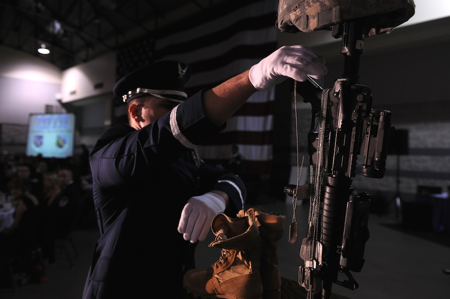 VALDOSTA, Ga.-- A member of the Moody Air Force Base Honor Guard places a set of dog tags on the Fallen Warrior Memorial during the Annual Awards Banquet Jan. 29. Six sets of dog tags were placed on the memorial to honor the fallen warriors of the 23rd Wing and the 93rd Air Ground Operations Wing. (U.S. Air Force photo/Airman 1st Class Benjamin Wiseman)(RELEASED)