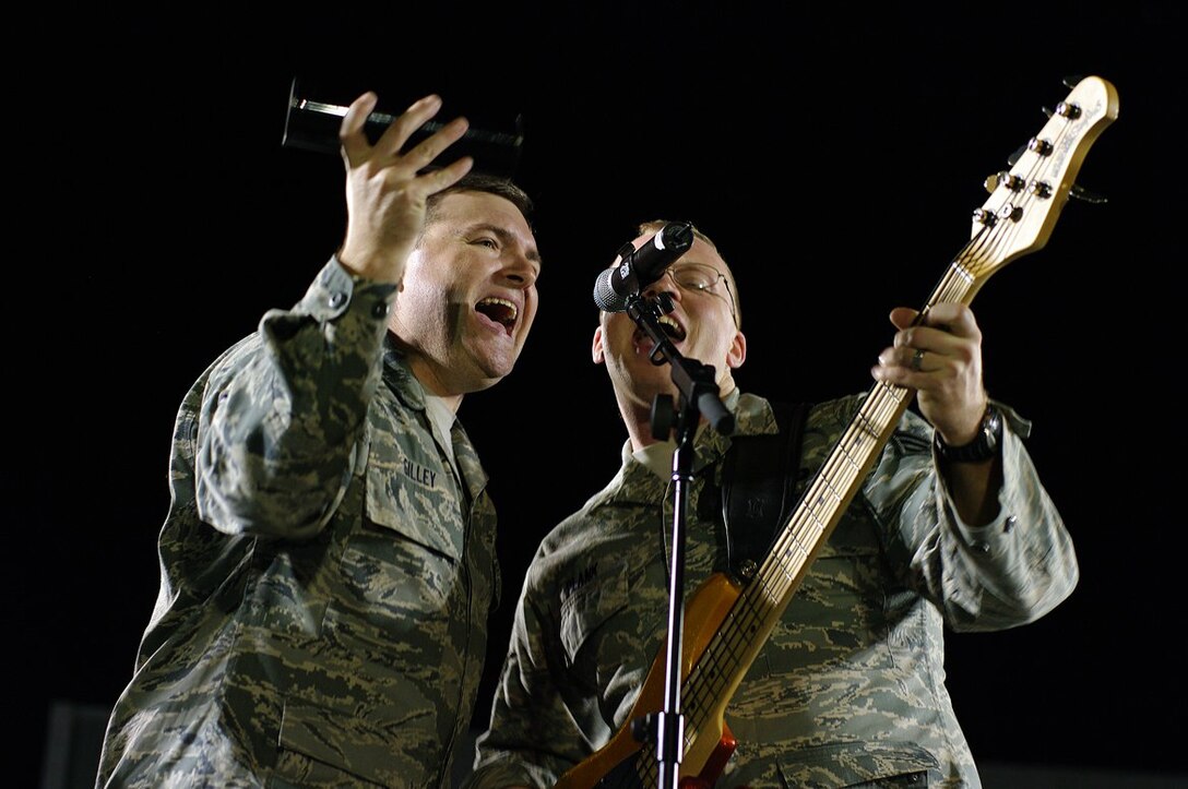 TSgt Jamie Gilley and SrA Brian Plank rock out in a nightime performance for deployed troops.