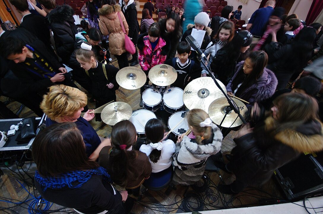 TSgt Christi McGowan shows an eager crowd of students her drumset at the Shubin School of Music in Bishkek, Kyrgyzstan.