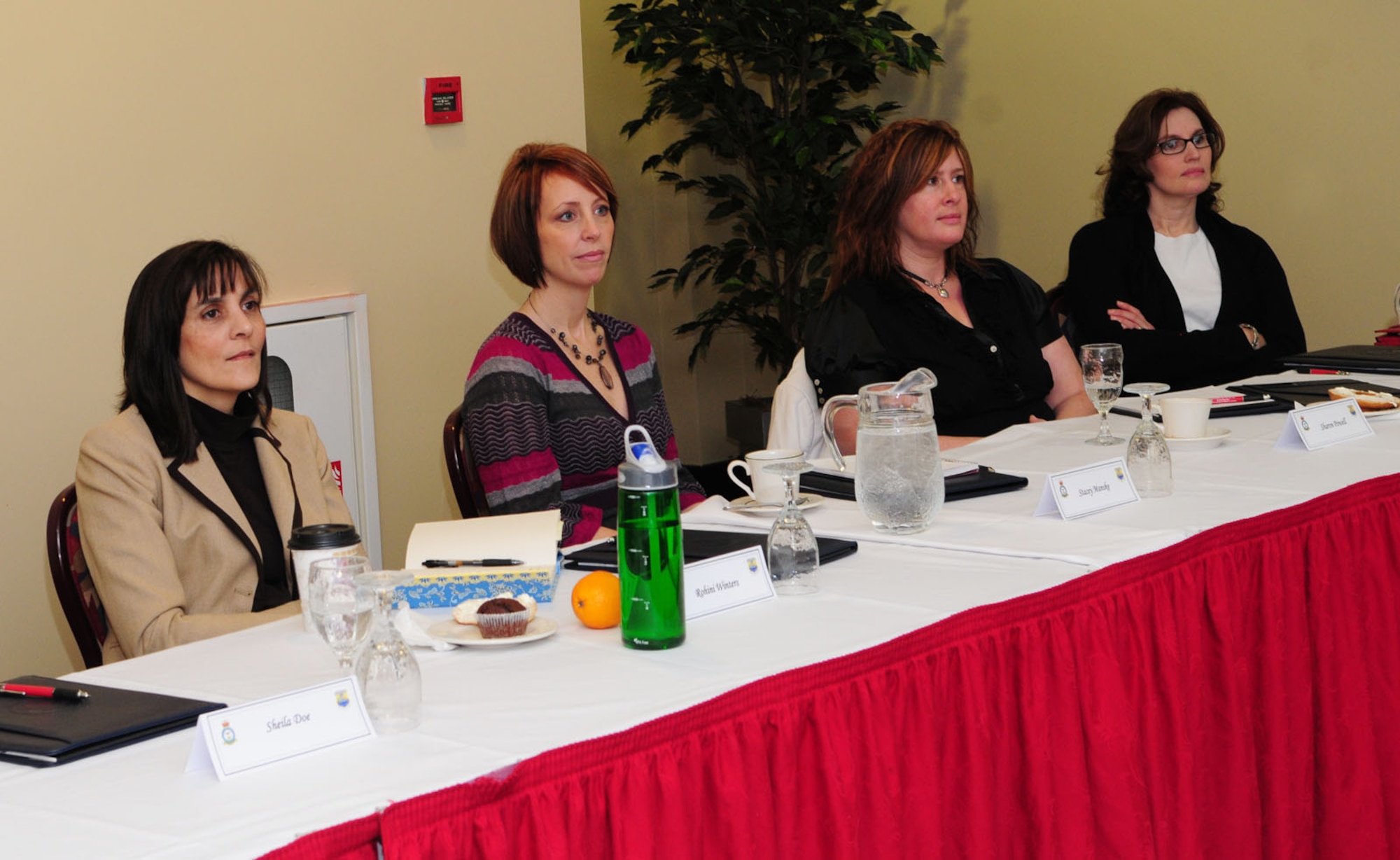 RAF MILDENHALL, England -- Rohini Winters, Stacey Manske, Sharon Powell and Sundie DeMarco, all spouses of base leadership, listen to a briefing by the school liaison officer at a spouses conference, specifically for commanders' and chiefs' spouses, Jan. 28, 2011, at the Galaxy Club. Commanders, chiefs and superintendents from the 100th Air Refueling Wing also met for a day-long conference. The wing leadership conference included topics such as perspectives of the U.S. Air Forces in Europe commander and 3rd Air Force commander, safety updates, and force management. (U.S. Air Force photo/Karen Abeyasekere)