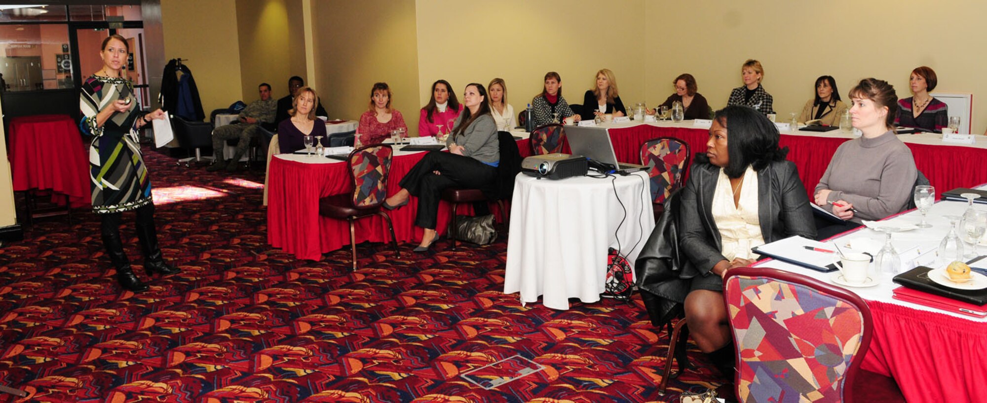 RAF MILDENHALL, England -- Lisa Thompson, left, 48th Mission Support Group Schools Liaison Officer, briefs commanders' and chiefs' spouses at a spouses conference Jan. 28, 2011. The wives of base leadership were given several briefings on topics including protocol, operational security and social media, spouse mentoring, stress management, and mentoring. (U.S. Air Force photo/Karen Abeyasekere)