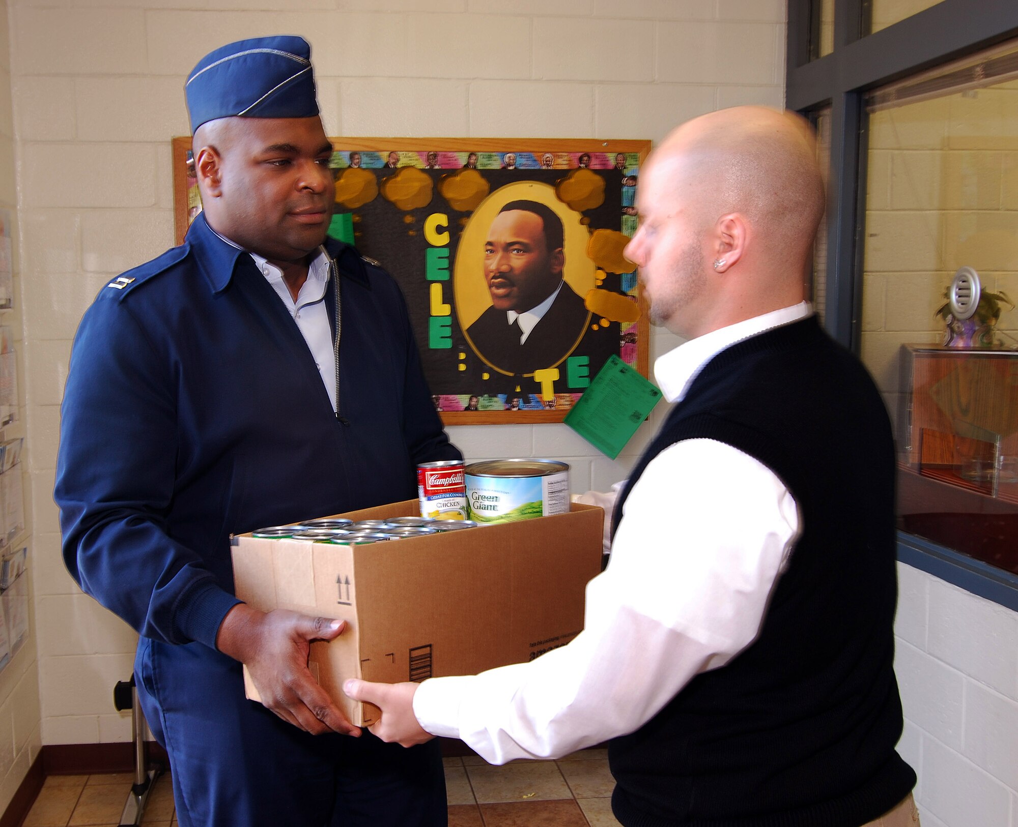 Capt. Darrell Bogan hands off a box of canned goods to Atlanta Salvation Army representative Harry Clark, Jan 24.  The items were donated by personnel of the 94th Airlift Wing, Dobbins Air Reserve Base, Ga. during the first-ever Dobbins Human Resource Development Council food and clothing drive and were part of an overall donation to multiple area charities.  (U.S. Air Force photo/ Brad Fallin)