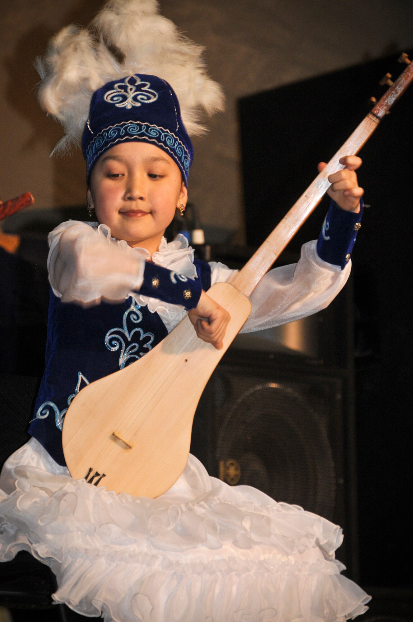 TRANSIT CENTER AT MANAS, Kyrgyzstan - A student from the Musical School for Gifted Kids skillfully play her Komuz, a traditional Kyrgyz instrument. The students showcased their talents for the Transit Center service members during a concert 31 Jan. (U.S. Air Force photo/Staff Sgt. Stacy Moless).(U.S. Air Force photo/Staff Sgt. Stacy Moless)