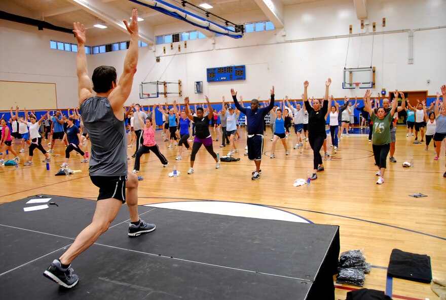 Tony Horton, creator of the fitness program, P90X, demonstrates an exercise routine for participants attending the fitness clinic in Kadena’s Risner Fitness Center, Jan. 29. The 90-minute workout session, as part of Armed Forces Entertainment’s “Ripped and Ready Tour,” led more than 200 people through a series of extensive exercises and yoga techniques to build and tone the body. (U.S. Air Force photo/ Airman 1st Class Maeson L. Elleman)