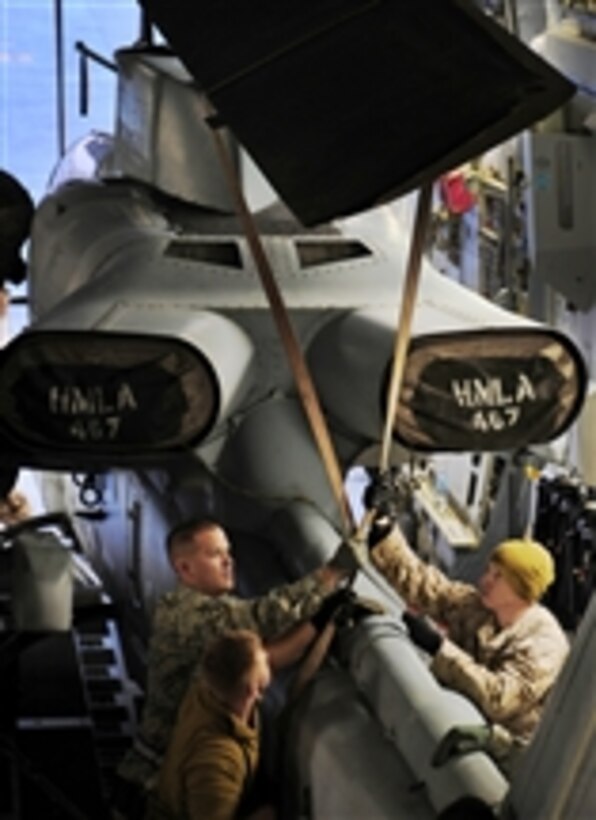 Senior Airman Eugene Lineham helps Marines secure an AH-1W Super Cobra aboard a C-17 Globemaster III aircraft for transportation to a forward location in Southwest Asia on Jan. 14, 2011.  Lineham is a member of the 386th Expeditionary Logistics Readiness Squadron.  