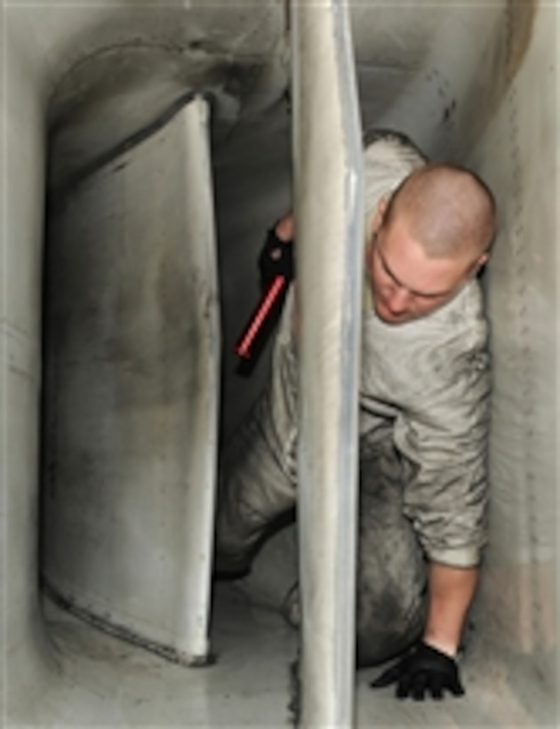 Senior Airman Jeffery Wood crawls from the air intake of a B-1 Lancer after performing a post-flight engine inlet inspection at Nellis Air Force Base, Nev., on Jan. 26, 2011.  Wood is deployed in support of Red Flag 11-2, a combined exercise that provides a realistic combat training environment to the U.S. and its allies.  Wood is a 28th Aircraft Maintenance Squadron crew chief.  