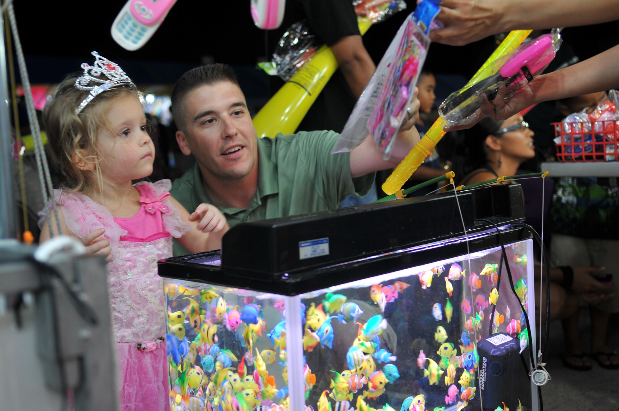 U.S. Marine Jason Mincolla and daughter Addison, age 4, pick a prize at one of the many games at AmericaFest 2011, July 1. AmericaFest takes place July 1 and 2, and is an event designed to build international relations with the local Okinawan community. (U.S. Air Force photo/Tech. Sgt. Angelique Perez)