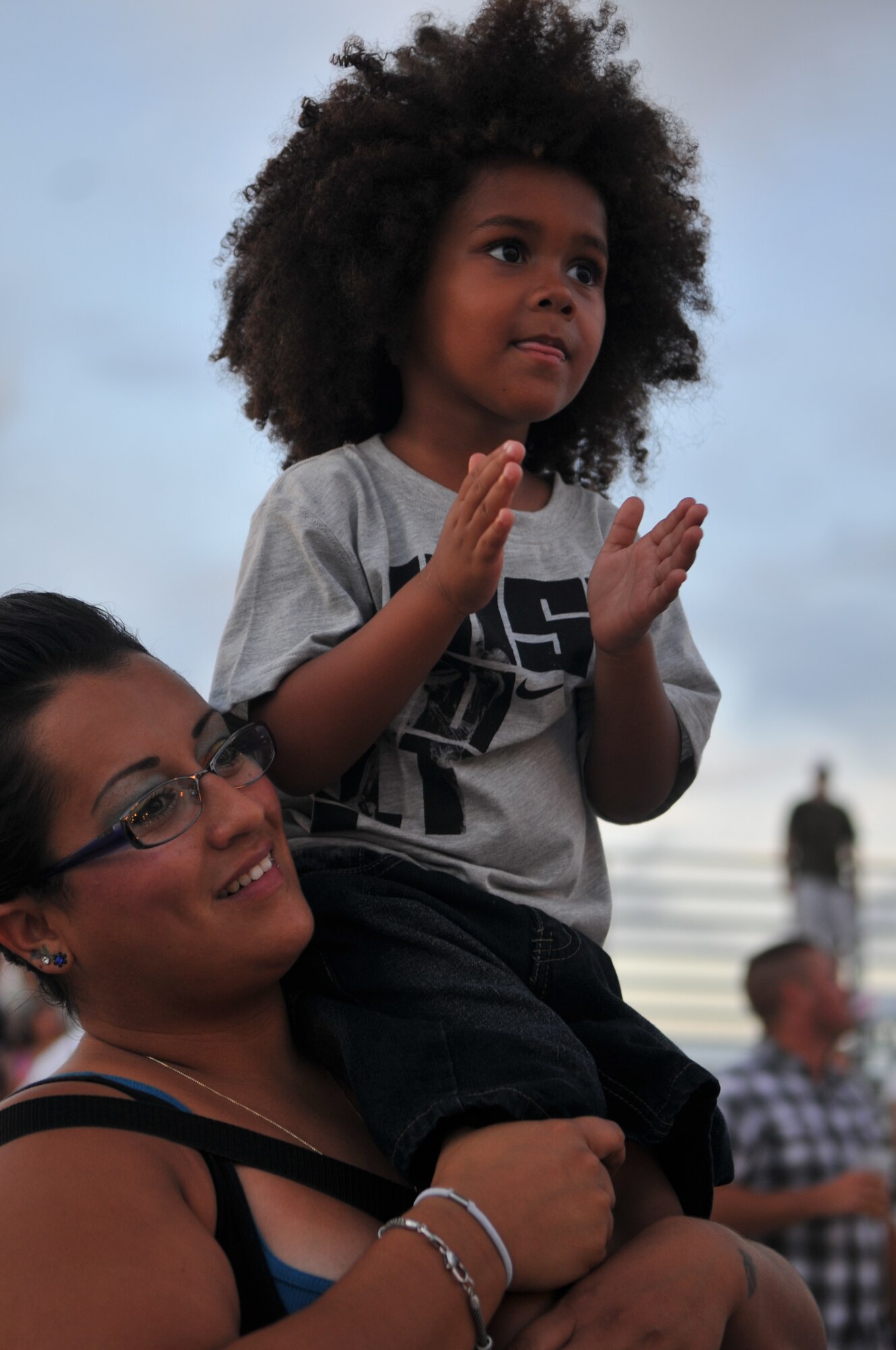 U.S. Marine Corps dependents Ambrose Amari, age 3, and his mom Amanda rock out to the band "12 Stones" as they perform during AmericaFest 2011, July 1.  AmericaFest takes place July 1 and 2, and is an event designed to build international relations with the local Okinawan community. (U.S. Air Force photo/Tech. Sgt. Angelique Perez)