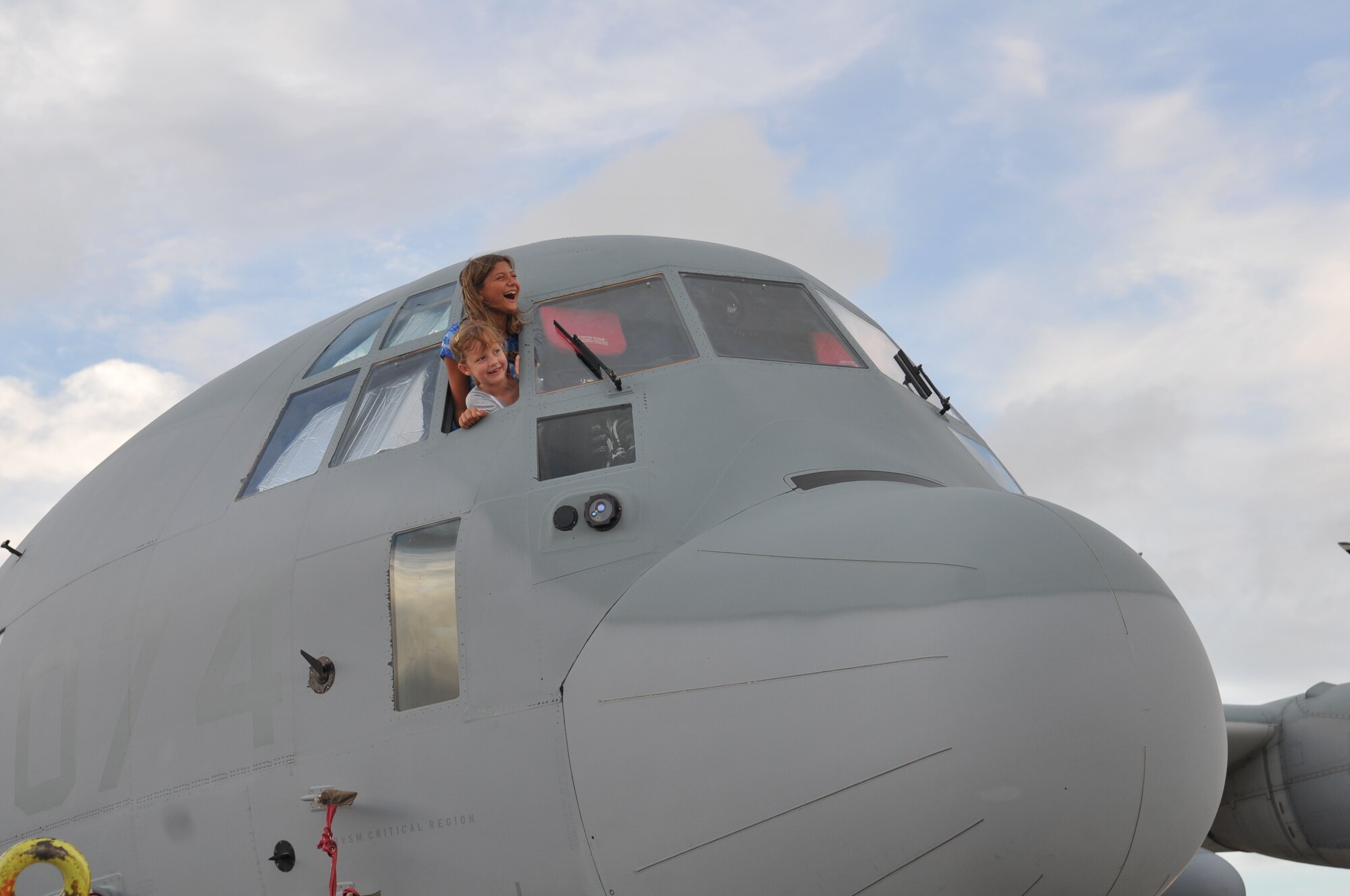 U.S. Marine Corps dependents Kaeliegh Lowman, age 12, and Ania Calbough, age 6, peek out the window of a C-130 on display during AmericaFest 2011, July 1. AmericaFest is an event designed to build international relations with the local Okinawan community and takes place July 1 and 2. (U.S. Air Force photo/Tech. Sgt. Angelique Perez)