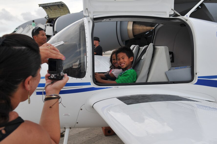 U.S. Air Force dependent Faith Ramirez takes a photo of her children, Jordan and Isla, in a Cessna on display during AmericaFest 2011, July 1. AmericaFest is an event designed to build international relations with the local Okinawan community and takes place July 1 and 2,. (U.S. Air Force photo/Tech. Sgt. Angelique Perez)