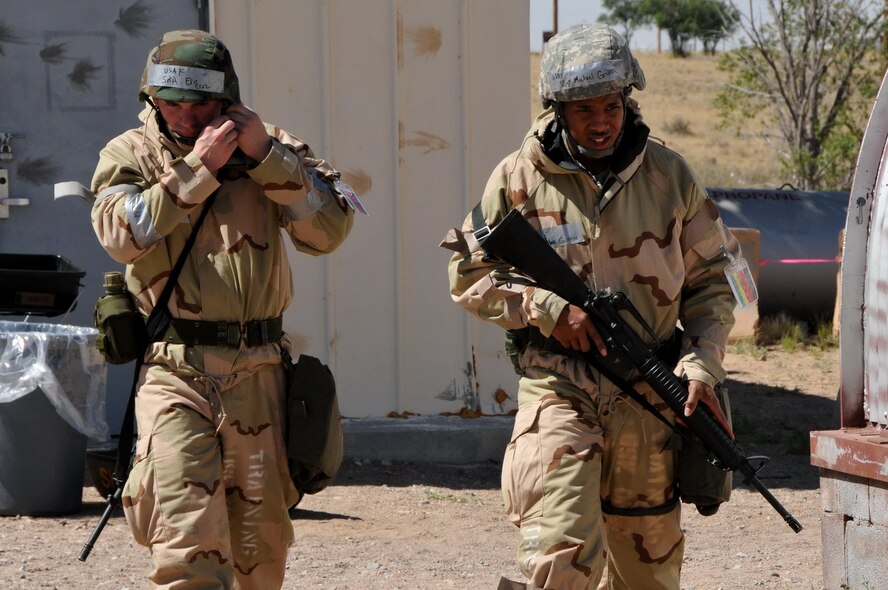 Senior Airman Eric Cruz, 377th Logistics Readiness Squadron, left, and Staff. Sgt. Michael Greene, 377 LRS, prepare to update the alarm and Mission-Oriented Protective Postures level status board.  U.S. Air Force Photo by Ken Moore