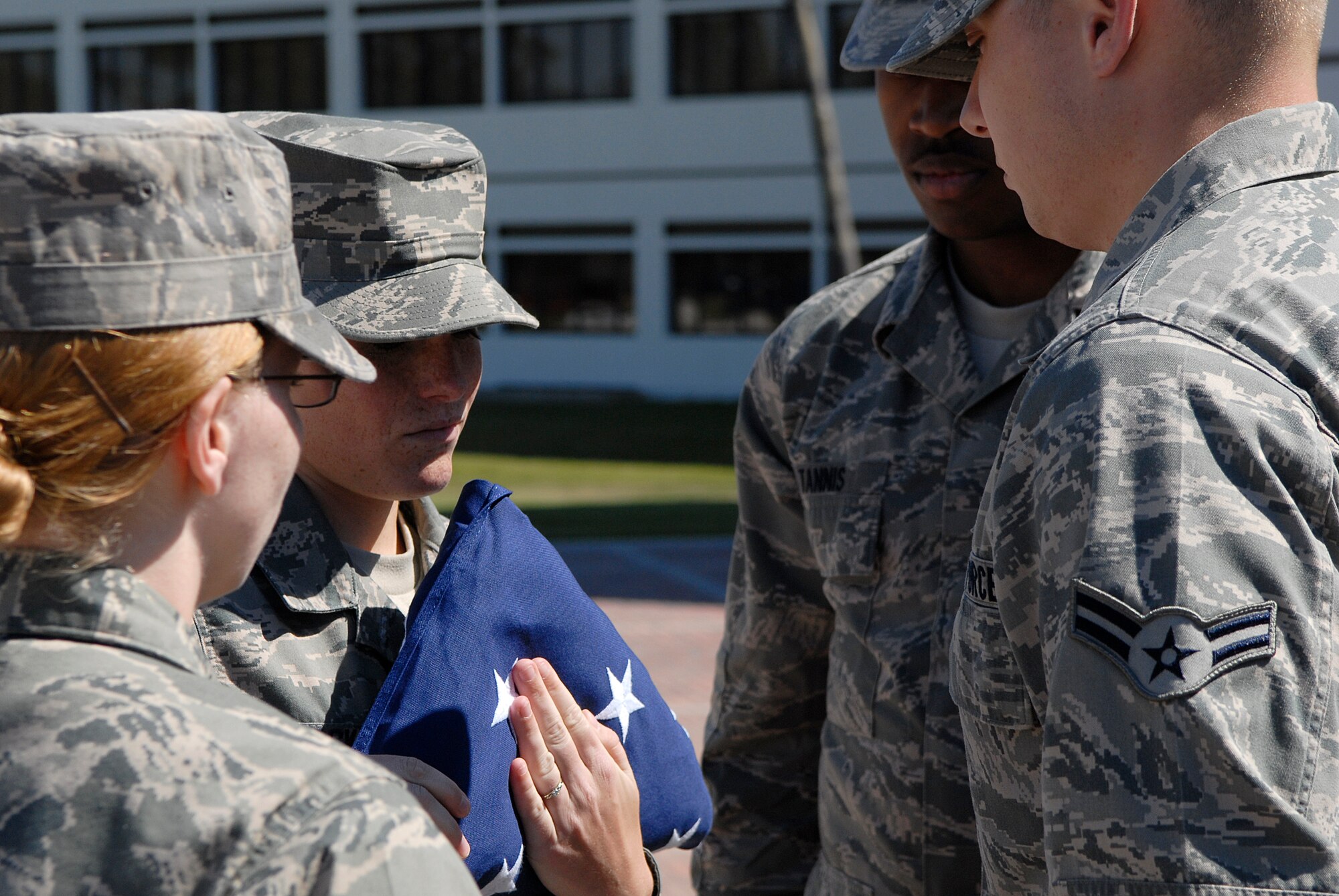 VANDENBERG AIR FORCE BASE, Calif. -- Senior Airman Danielle Voskuil, a 30th Comptroller Squadron member, takes control of the colors during a retreat ceremony at the headquarters building here Thursday, June 30, 2011.  The color guard members work together to ensure the flag is properly secured after the ceremony.  (U.S. Air Force photo/Staff Sgt. Andrew Satran) 
  