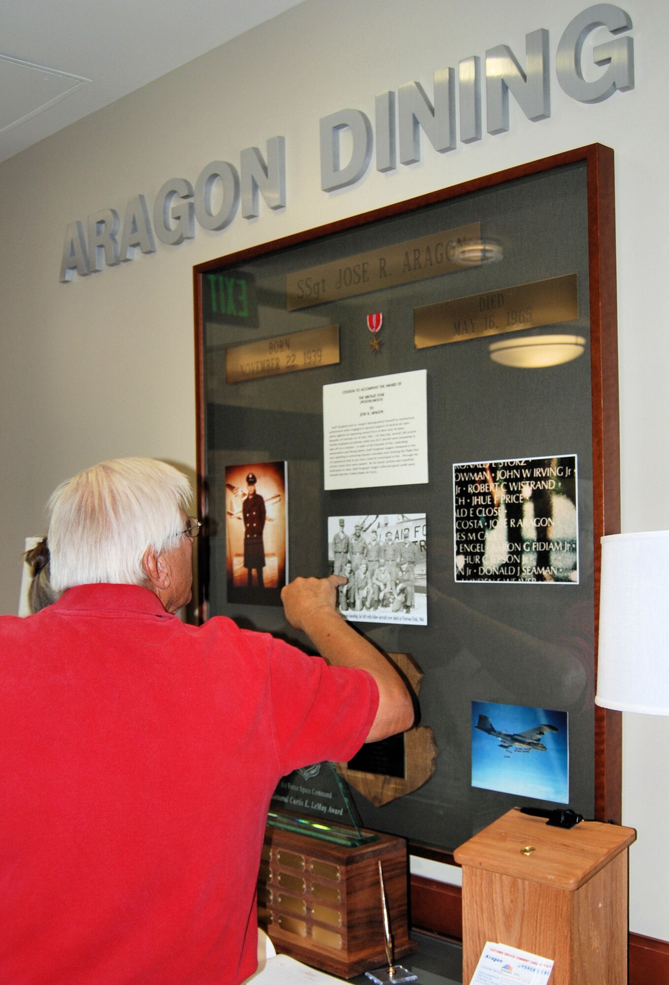 Leo Hrdlicka points to a flight photo as he recalls the names of Airmen he served with in the 1960s on Peterson Field. In the flight photo is Staff Sgt. Jose Aragon, who distinguished himself by meritorious achievement while engaged in ground support of Tactical Air Operations against an opposing armed force at Bien Hoa Air Base, Republic of Vietnam on May 16, 1965. (Air Force photo/Airman 1st Class Jessica Hines)