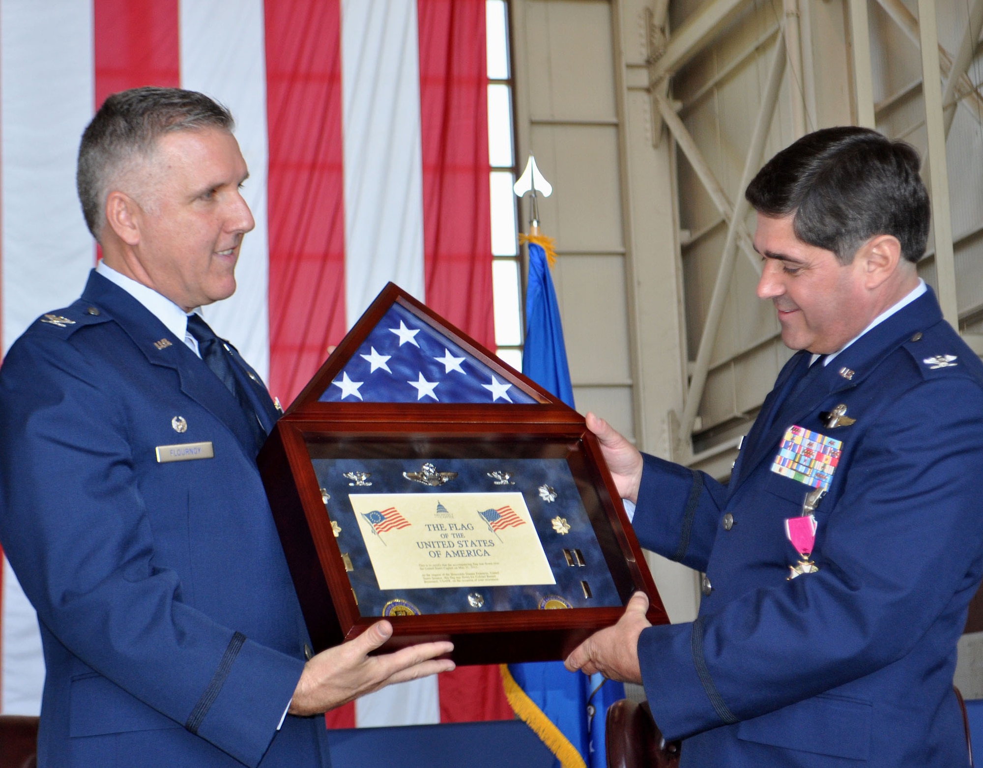 TRAVIS AIR FORCE BASE, Calif --349th Air Mobility Wing Commander, Col. Jay Flournoy, presents Col. Barrett Broussard, vice commander, with a shadow box at his retirement June 25. The shadow box represents his career, and contains a flag flown over the U.S. Capitol. Col. Broussard retired after giving 27 years to the Air Force, both active and Reserve. (U.S. Air Force photo/Senior Master Sgt. Ellen L. Hatfield)