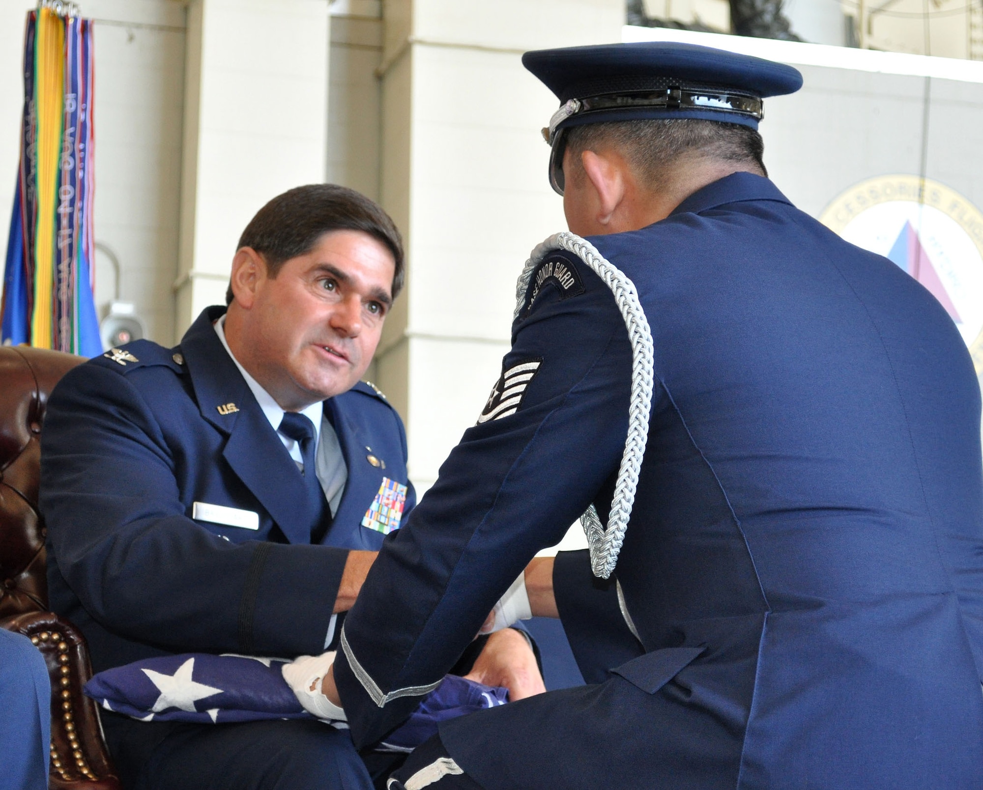 TRAVIS AIR FORCE BASE, Calif -- "On behalf of a grateful nation..." Col. Barrett Broussard is presented a flag at his retirement ceremony June 25, at Travis. Col. Broussard retired after 27 years of duty, both active and Reserve. He intends to stay in the Travis area, and continue flying for his airline job, splitting his time between here, and his hometown in Louisiana. For the full story and photos, see the July Contact magazine. (U.S. Air Force photo/Senior Master Sgt. Ellen L. Hatfield)