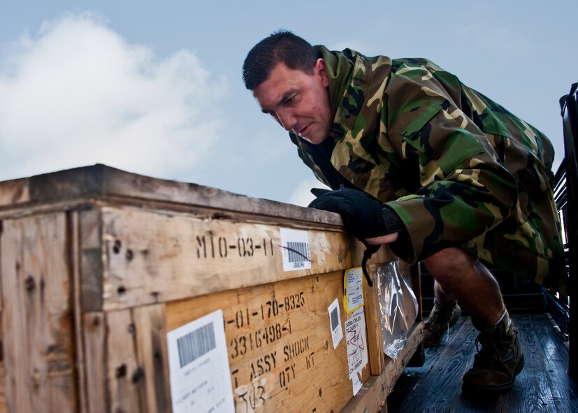 Eric Bonebrake, 96th Logistics Readiness Squadron, moves a box toward the back of his truck at Eglin.  Mr. Bonebrake works as a pick-up and delivery driver within the vehicle operations section under 96th LRS.  He and other delivery drivers shuttle supplies to and from various maintenance locations twice daily.  Vehicle operations is part of the larger Distribution flight under 96 LRS.  (U.S. Air Force photo/Samuel King Jr.)   