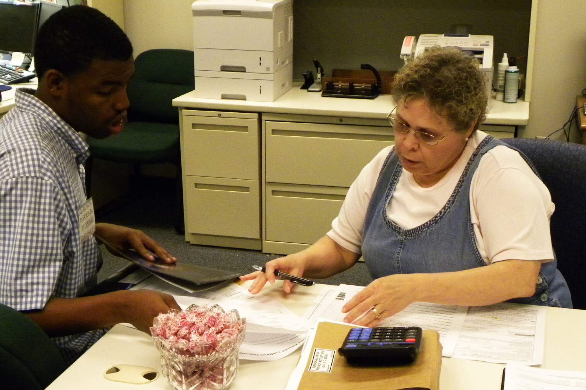 Debbie Semira, military pay technician with the 307th Bomb Wing, assists Airman Darius Burgy with finance paperwork at Barksdale Air Force Base, La., June 21, 2011.  Burgy was in-processing into the 307th BW prior to leaving for basic military training. In-processing for the 307th BW is overseen by the personnel relocations staff. (U.S. Air Force Photo/Staff Sgt. Ted Daigle)