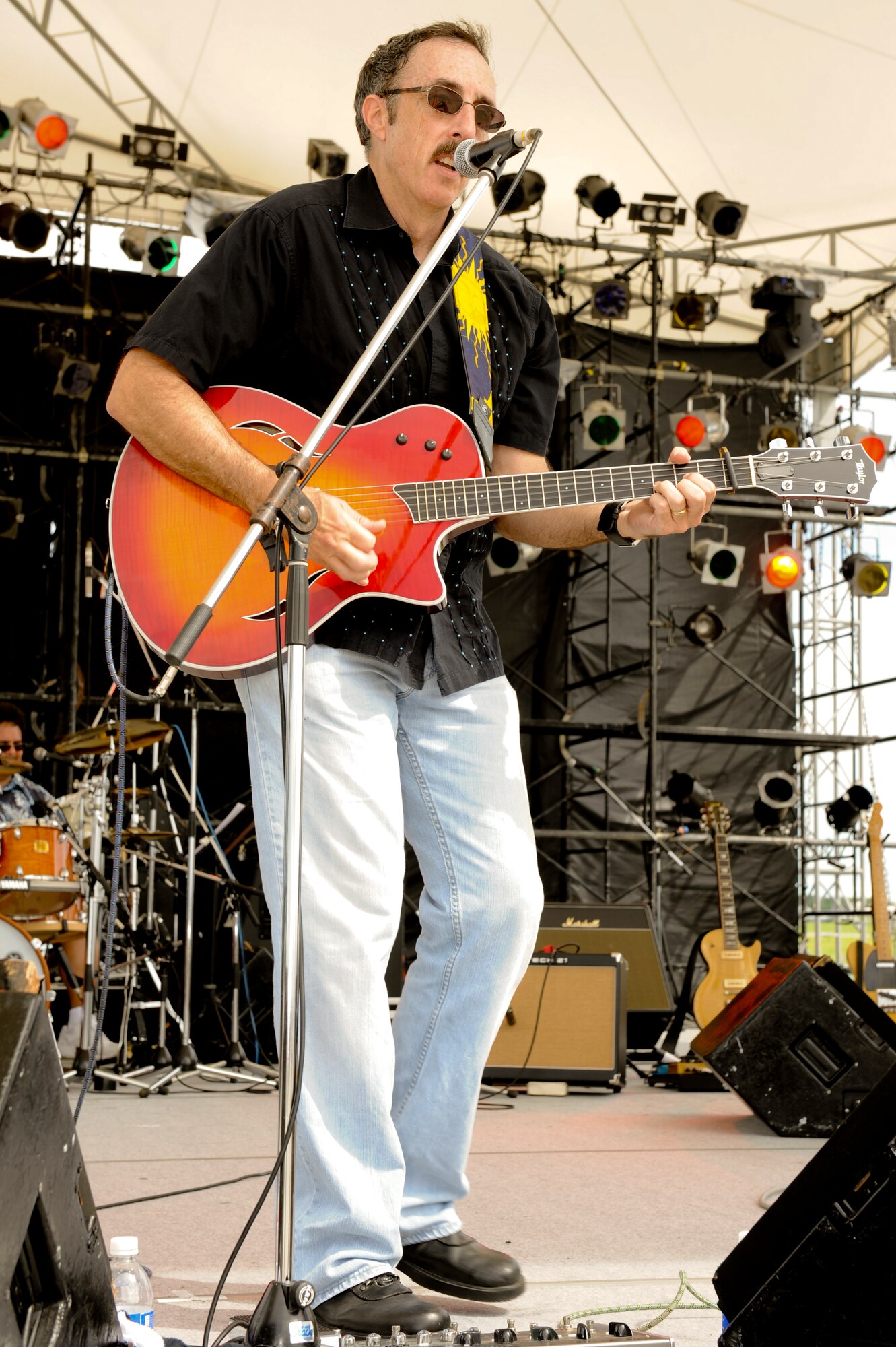 The lead singer of Kluso, a local band here in Okinawa, sings for military and family members during Kadena’s AmericaFest, Kadena Air Base, Japan, July 1. AmericaFest was a family event where military and family members got a chance to see Kadena’s aircraft and celebrate Independence Day with entertainment and a variety of carnival like foods. (U.S. Air Force photo/Airman 1st Class Brooke P. Beers)