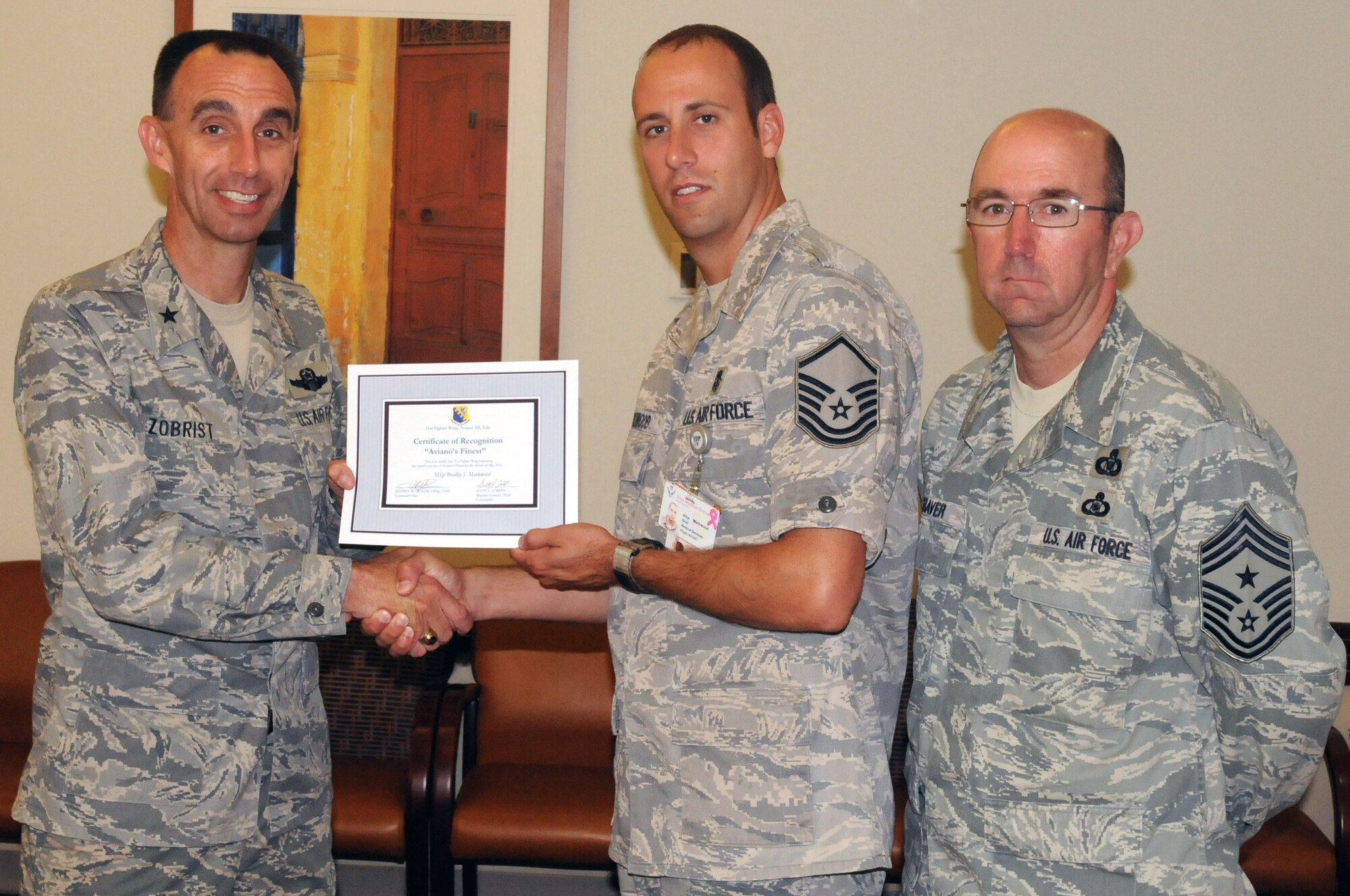 Brig. Gen. Scott J. Zobrist, 31st Fighter Wing commander, along with 31st FW Command Chief Master Sgt. Jeffrey Craver, congratulate Master Sgt. Bradley Markwood, 31st Medical Operations Squadron medical services NCO in charge, on his selection as one of Aviano's Finest. (U.S. Air Force photo/Airman LaVel Sterling)