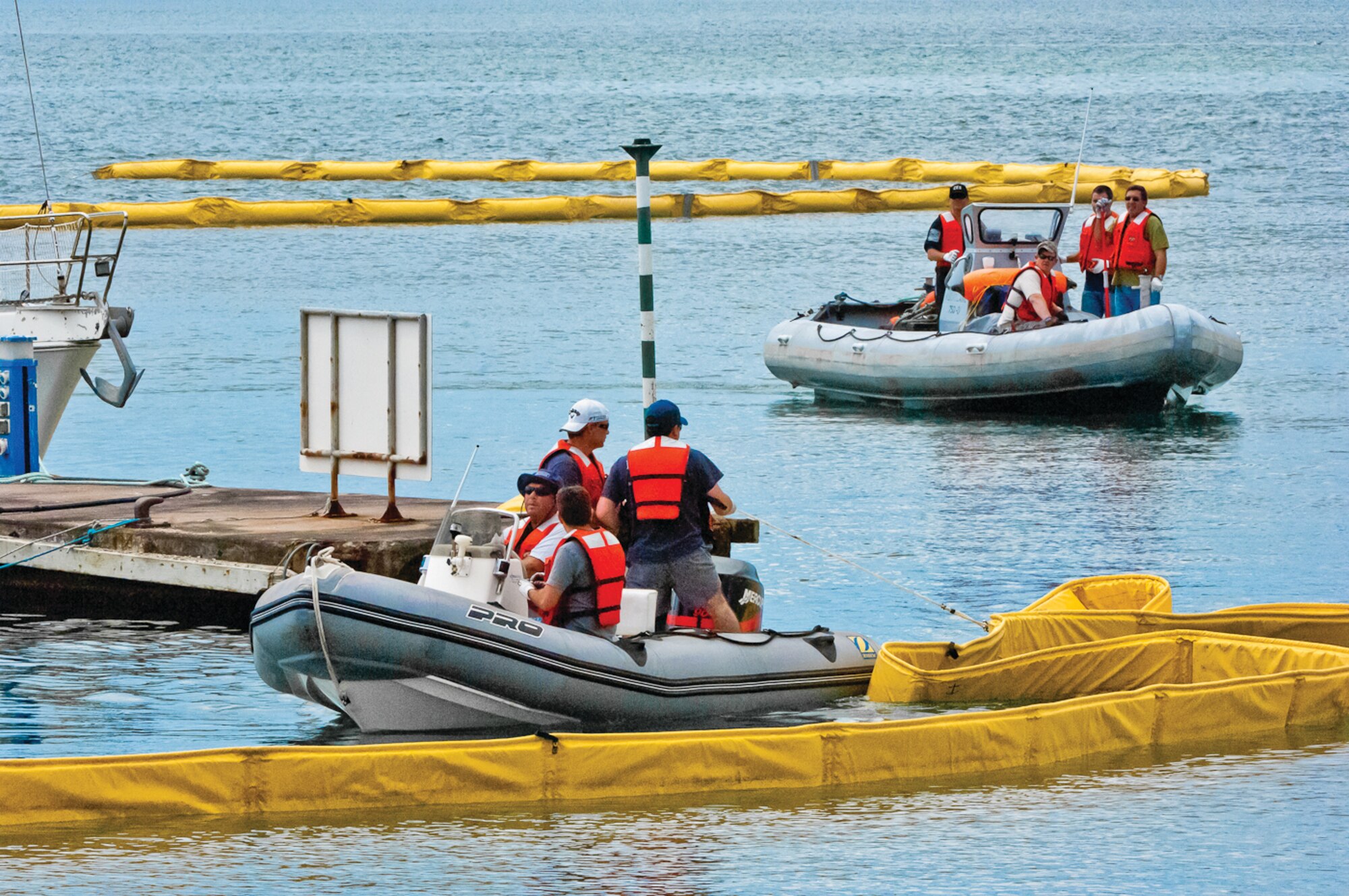 Members of Lajes Field's 65th Civil Engineer Squadron put booms in place to control a simulated fuel spill during a spill-response exercise in Praia da Vitoria Bay June 15, 2011. (Photo by Lucas Silva)