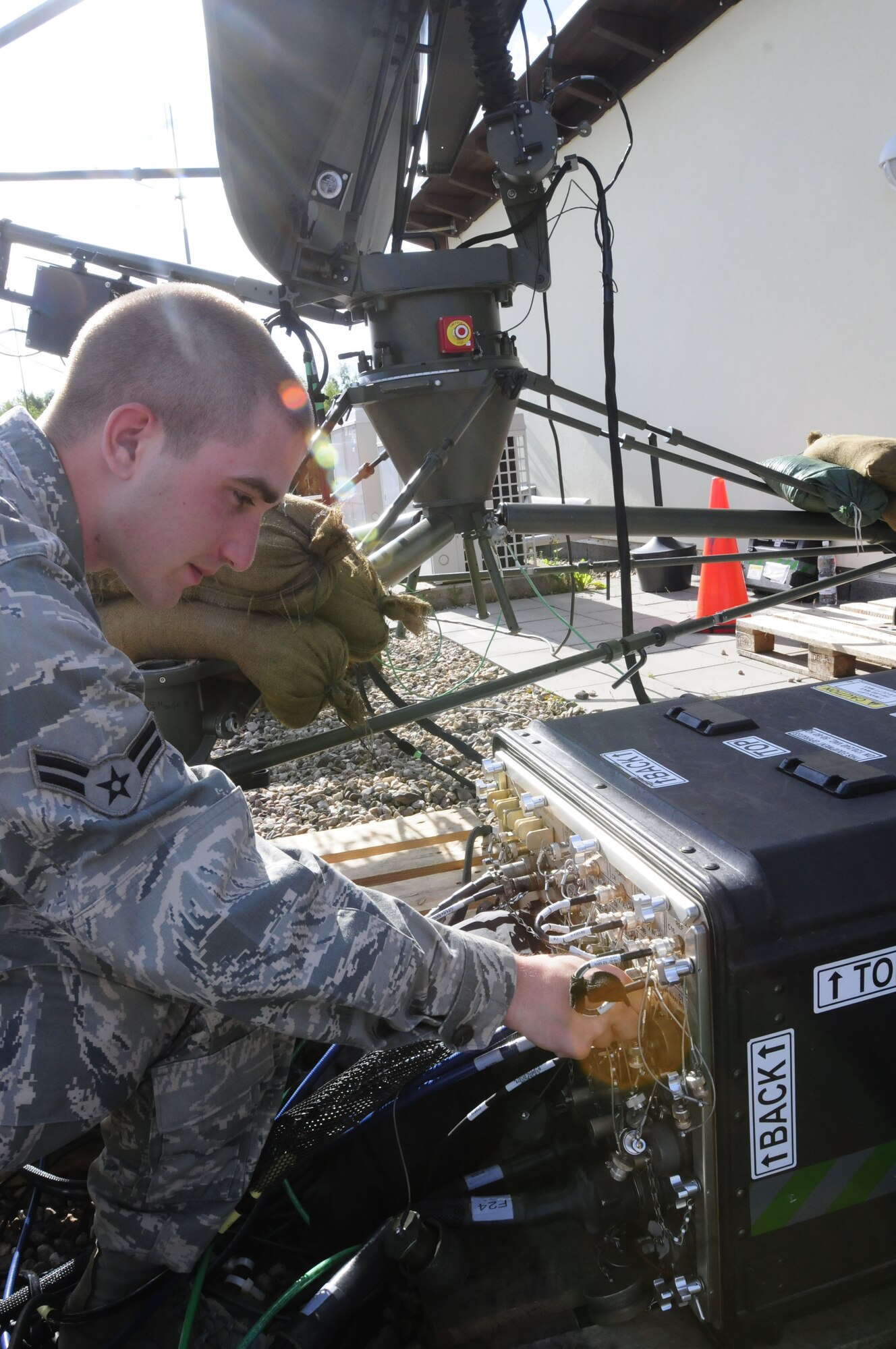 Airman 1st Class Alex Daren, 1st Combat Communications Squadron radio frequency transmission technician, attaches cables to a Remote Fiber Optic Unit in support of Allied Strike 2011 at Grafenwoehr Training Area, Germany, June 26, 2011. A RFOU controls satellite movements, which makes it possible to acquire data in order to utilize internet, networks and phones. Airman Daren was part of an 11-person Combat Communications team from Ramstein that supported the exercise. Allied Strike is Europe’s premier Close Air Support exercise, held annually to conduct robust, realistic CAS training that helps build partnership capacity among Allied NATO nations and refine the latest operational CAS tactics. (U.S. Air Force photo by Airman 1st Class Desiree W. Esposito)