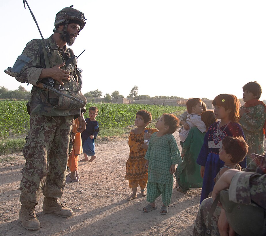 An Afghanistan National Army soldier with the 2nd Kandak, 1st Brigade, 215th Corps talks to local children during a momentary halt during a security patrol here, July 1. The partnership between the Marines of 2nd Squad, Weapons Platoon, Alpha Company and their Afghan brothers-in-arms is an example for the rest of the infantry squads in 1st Battalion, 3rd Marine Regiment to emulate. The ANA soldiers partnered with 2nd Squad have taken on independent responsibility of the operations in their area to include sweeping for improvised explosive devices and taking part in the planning of the patrols in the area.