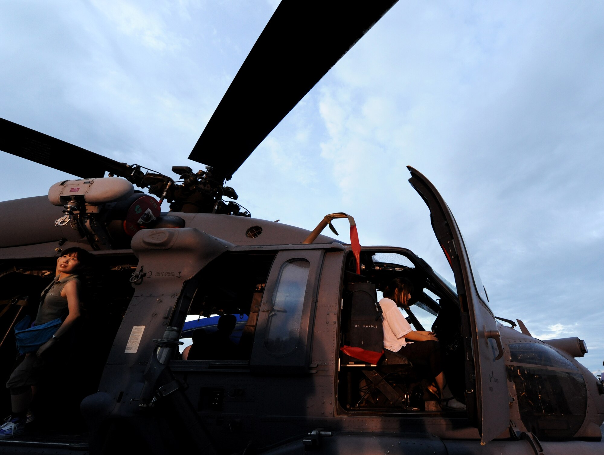 Two onlookers from the local community look at a U.S. Air Force HH-60 Pave Hawk helicopter at AmericaFest on Kadena Air Base, Japan, July 2. Fourteen American aircraft from military bases across the island and country, as well as four Japan AirSelf-Defense Force aircraft came together on Kadena to showcase the capabilities of the partnered forces inJapan. (U.S. Air Force photo/ Airman 1st Class Jarvie Z. Wallace)