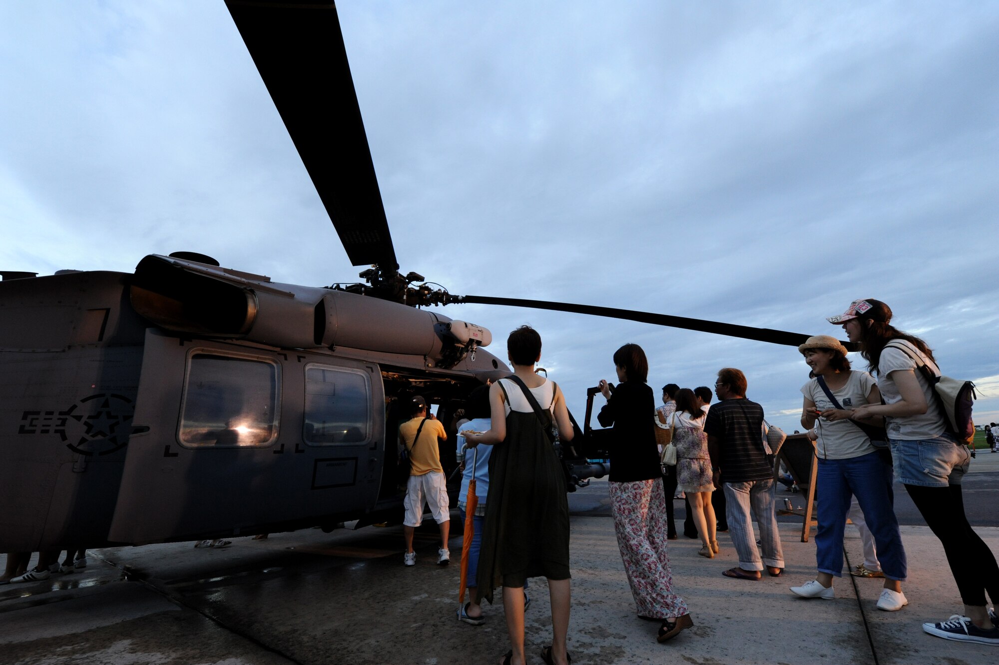 A group of onlookers look at a U.S. Air Force HH-60 Pave Hawk helicopter at AmericaFest on Kadena Air Base, Japan, July 2. Fourteen American aircraft from military bases across the island and country, as well as four Japan AirSelf-Defense Force aircraft came together on Kadena to showcase the capabilities of the partnered forces in Japan. (U.S. Air Force photo/ Airman 1st Class Jarvie Z. Wallace)