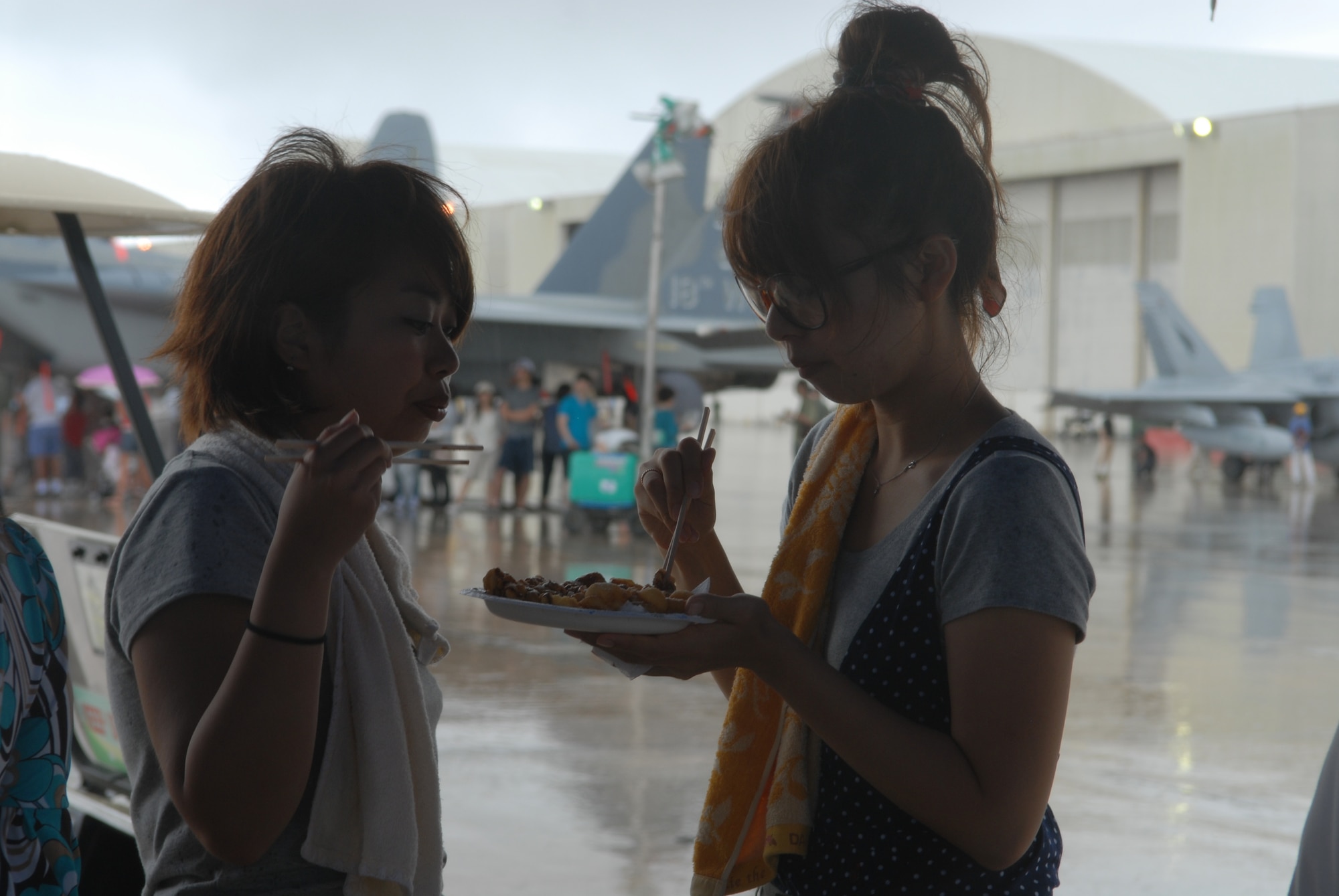 Local citizens enjoy funnel cake with chopsticks during America Fest July 2, at Kadena Air Base, Japan. America Fest was held July 1 and 2 at on Kadena?s flight line to help celebrate July 4th. The event was open to all Status of Forces Agreement status ID holders and to all Japanese citizens July 2. The open house included musical guests, food and game booths and a wide variety of aircraft from the Air Force, Navy, Army, Marine Corps and Japan Air Self Defense Force as well. (U.S. Air Force photo/Senior Airman Sara Csurilla)