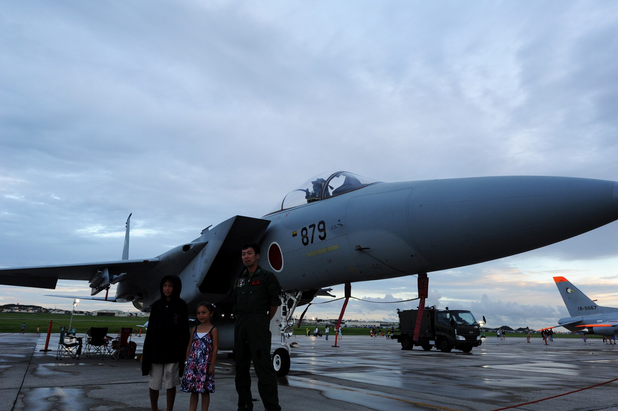 Capt. Takashi Akimoto, Japan Air Self Defense Force F-15 pilot with the 83rd Air Group, Naha Air Base, poses for photo with two American children at AmericaFest on Kadena Air Base, Japan, July 2. AmericaFest gave Status of Forces Agreement-status members as well as local Okinawans the chance to celebrate Independence Day in a carnival atmosphere with rides, games and live entertainment. (U.S. Air Forcephoto/ Airman 1st Class Jarvie Z. Wallace)